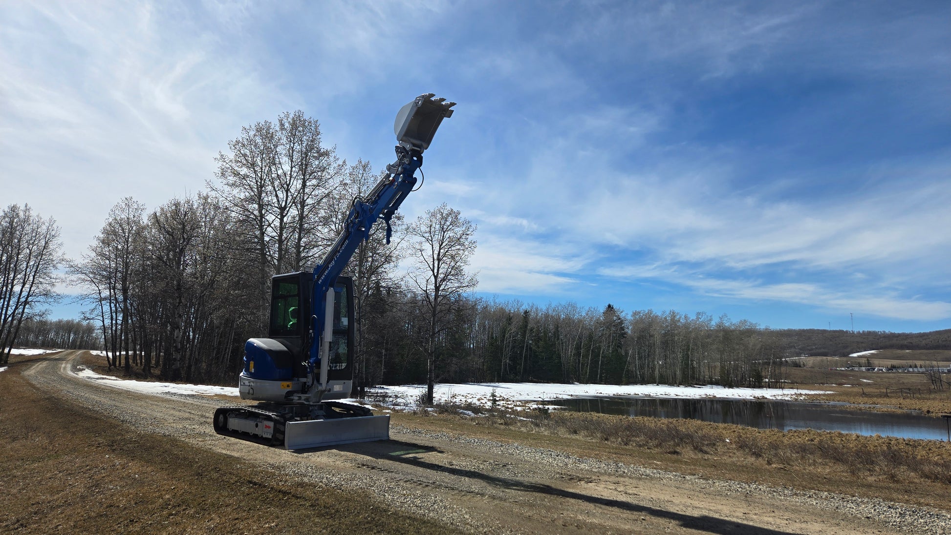 JT5350 mini excavator JoyT5 working in Canada with bucket lifted compact Kubota engine excavator for rural construction projects and small digging work

