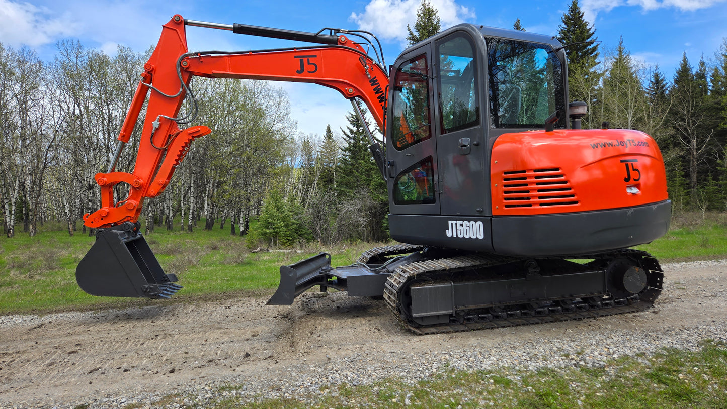 Close side view of JT5600 JoyT5 6 ton mini excavator with Yanmar engine, hydraulic boom, crawler tracks and digging bucket lifted