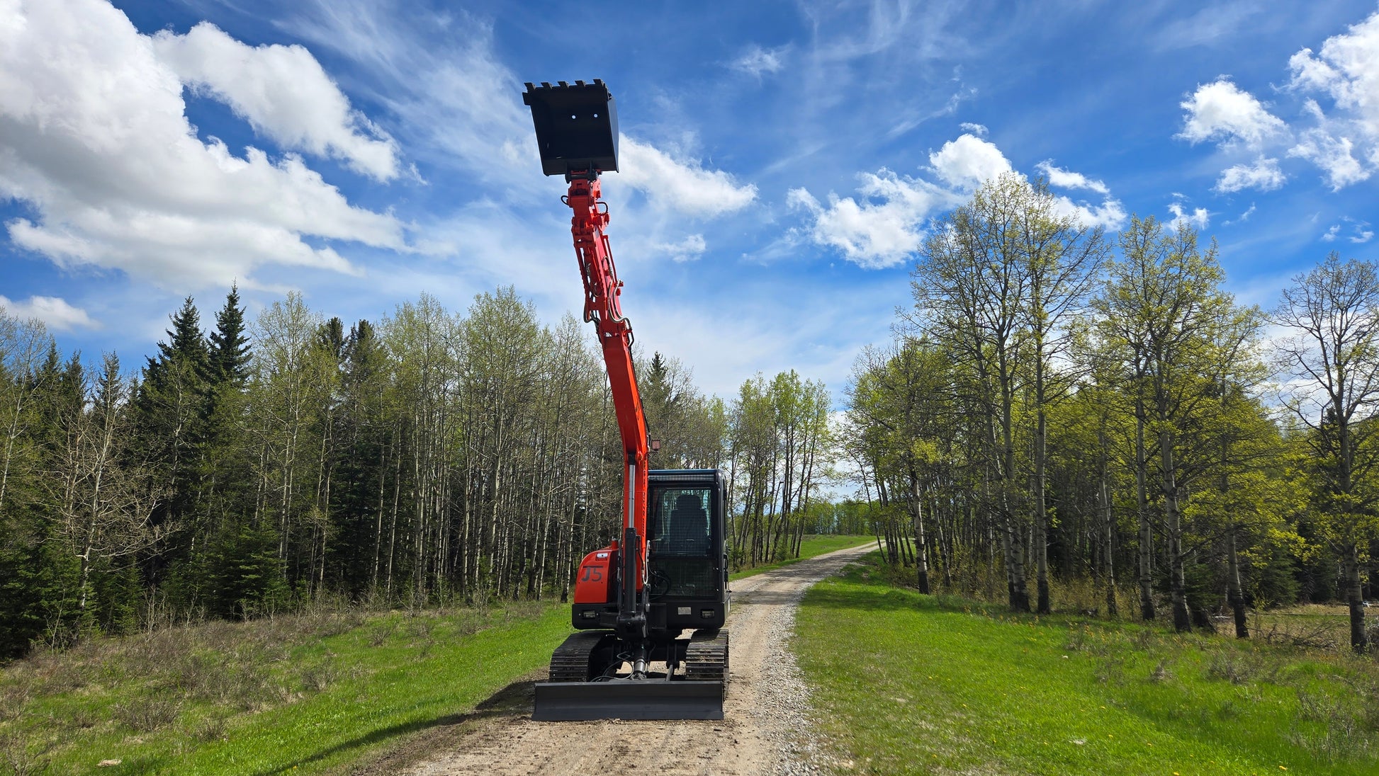 Front view of JT5600 JoyT5 6 Ton excavator with Yanmar engine and extended boom lifting bucket high in the air