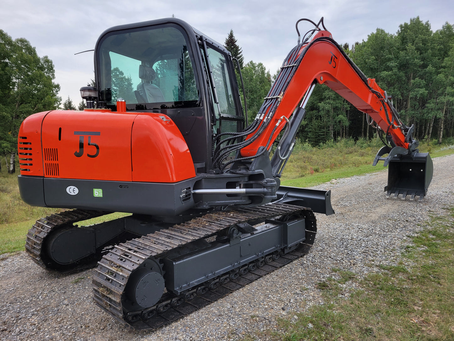 JT5600 mini excavator close-up view showing rubber tracks, hydraulic system, and operator cabin