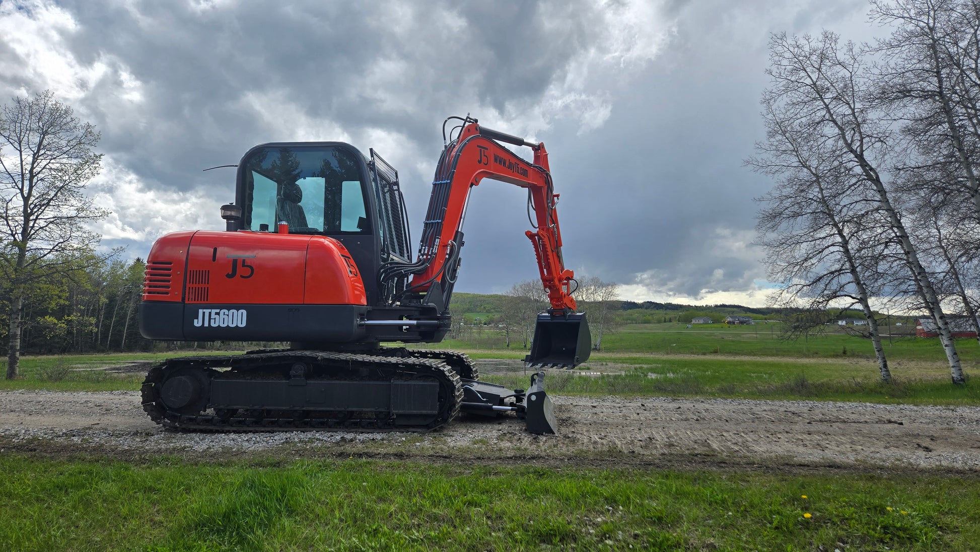 JT5600 6 ton mini excavator left side view with dozer blade down and bucket lifted