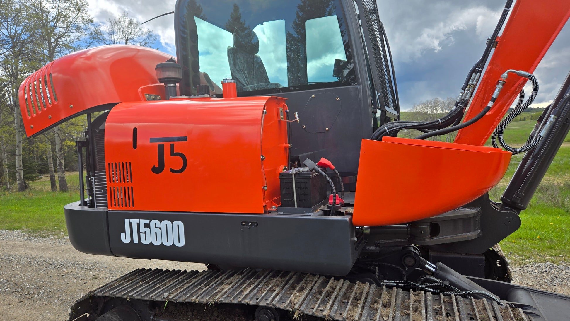 JT5600 mini excavator side view with open engine compartment showing durable build
