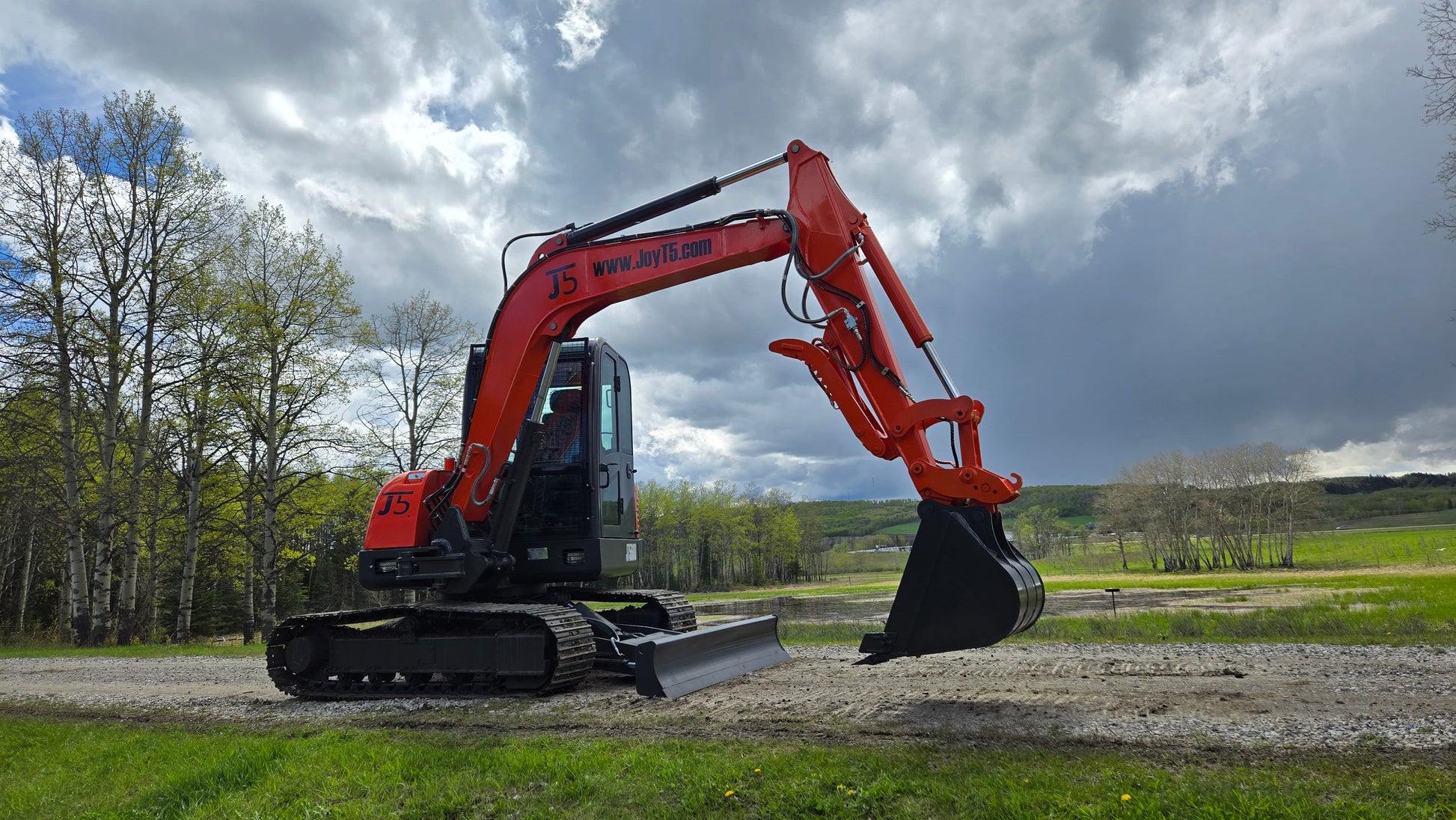 JT5600 mini excavator with dozer blade and boom arm in field view