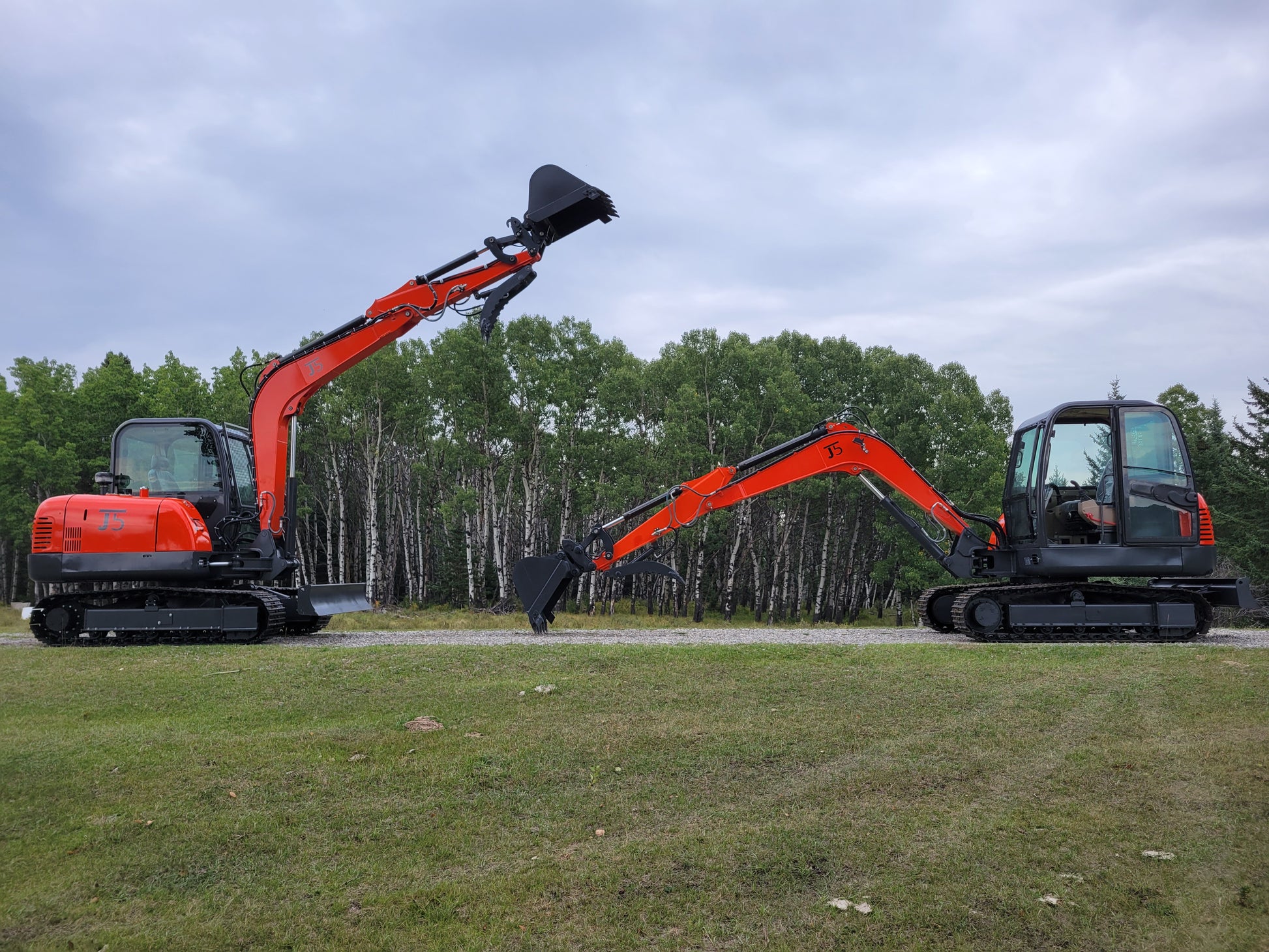 Two JT5600 mini excavators side by side with raised arms and buckets – JoyT5 6 ton diggers