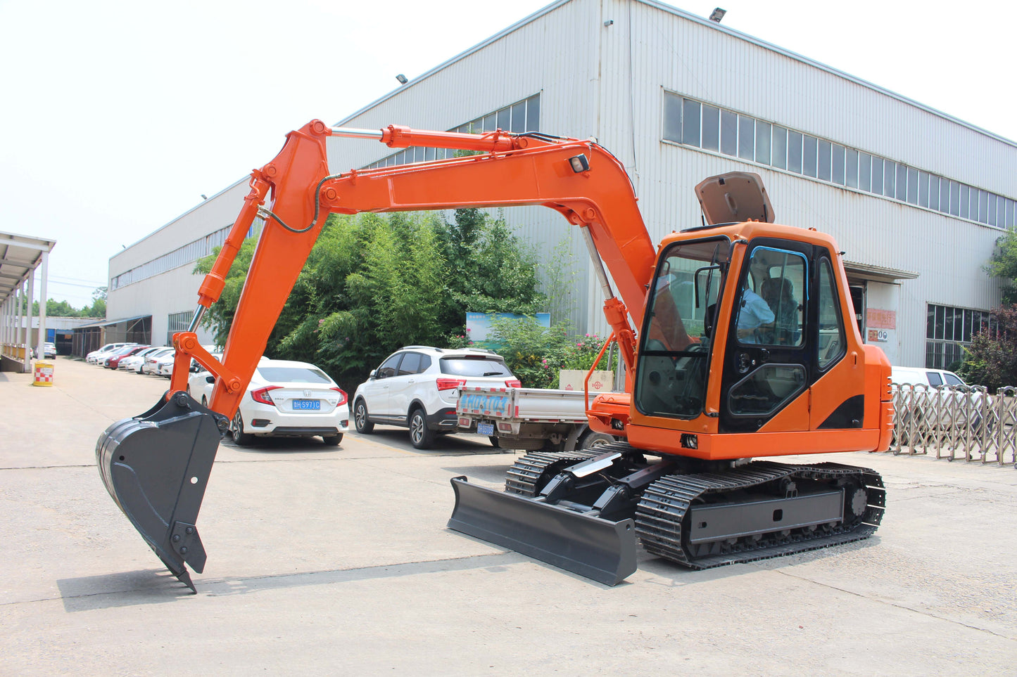 JT5800 8 ton mini excavator equipped with hydraulic thumb and full cab shown at industrial yard in Canada powered by Yanmar diesel with JoyT5 dealer support