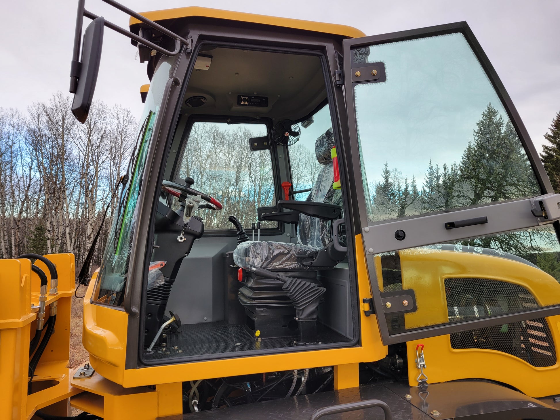 JT5WL1200 Compact Wheel Loader 1.2 Ton for Sale in Canada showing open operator cabin with steering seat and joystick controls designed for comfort in construction and snow removal work
