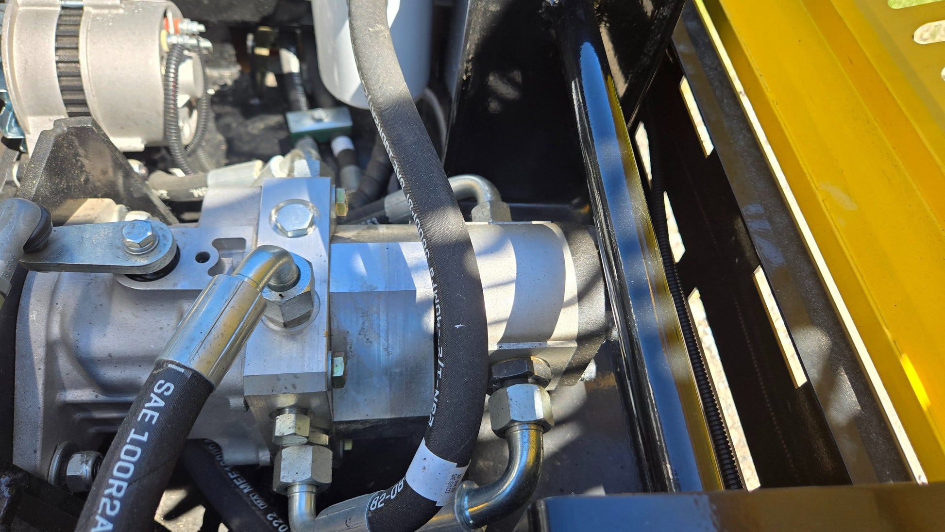 Close view of hydraulic pump assembly and hose fittings in JT5DR35 drum roller used for road construction and soil compaction in Canada