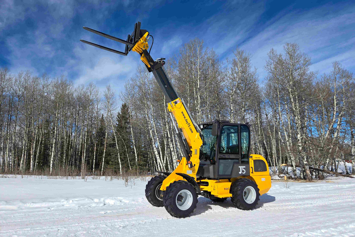 JT5WL1000 one ton compact wheel loader lifting forks in snow for farm and construction use across Canada