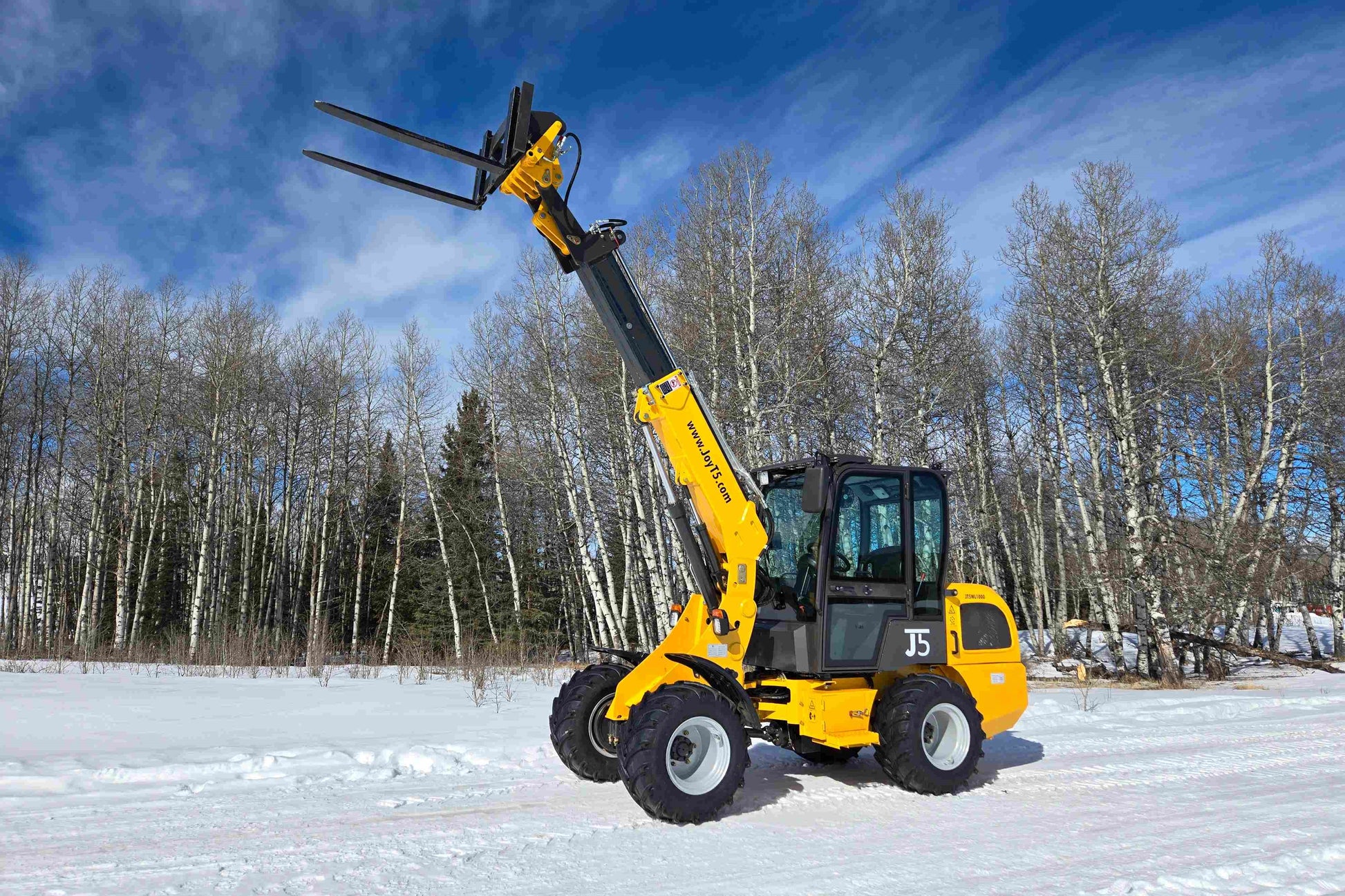 JT5WL1000 one ton compact wheel loader lifting forks in snow for farm and construction use across Canada