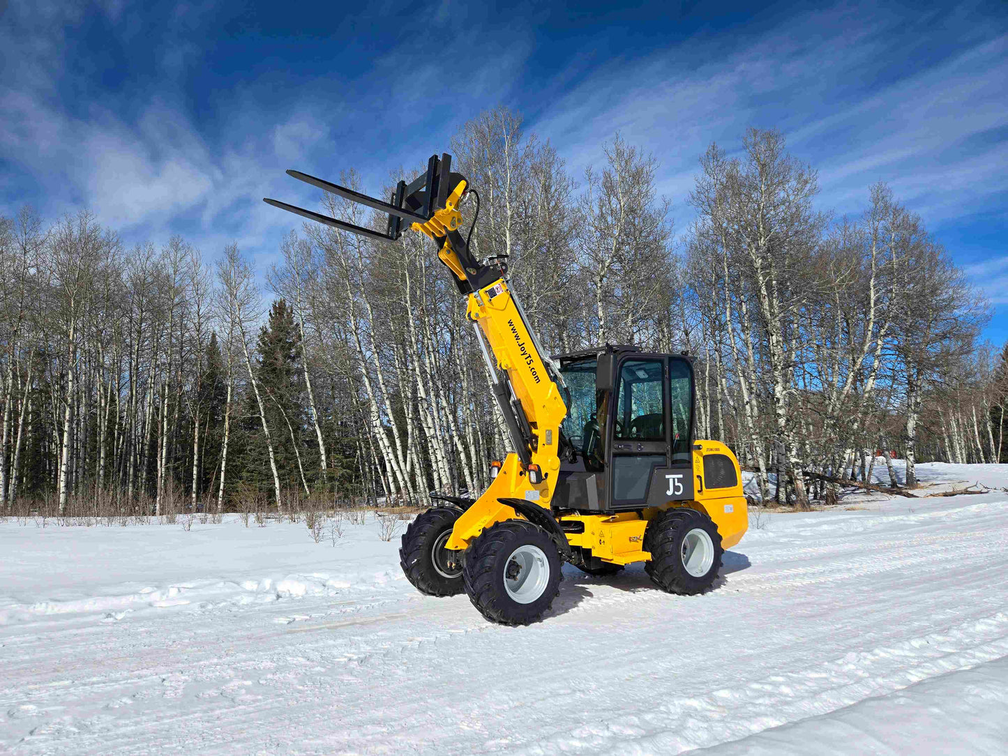 JT5WL1000 compact 1 ton wheel loader lifting pallet forks in snowy Canada landscape for farm construction and landscaping use