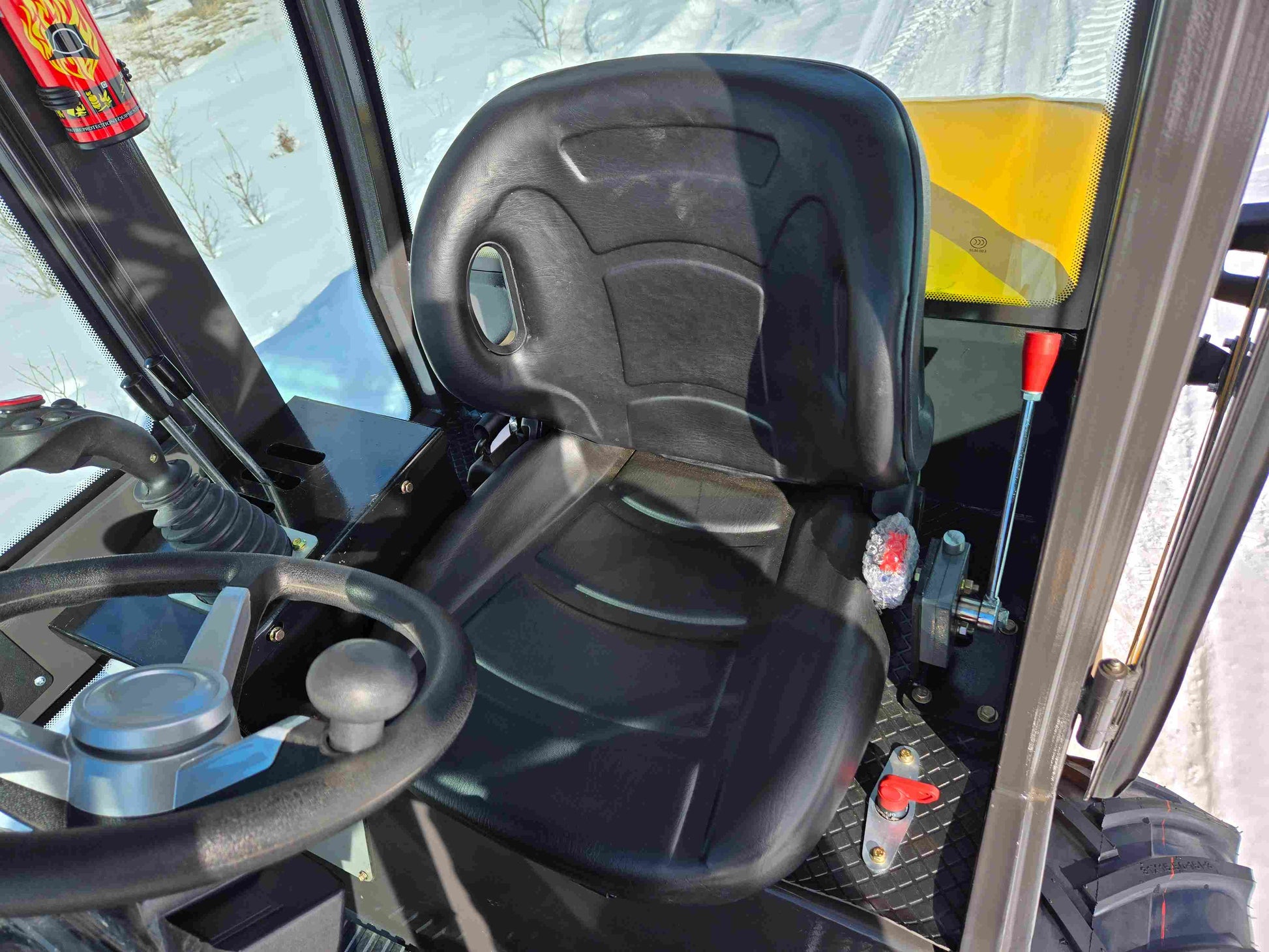JT5WL1000 Compact Wheel Loader 1 Ton 2200 lbs for Sale Canada showing operator seat, steering wheel, and control levers inside the cabin.