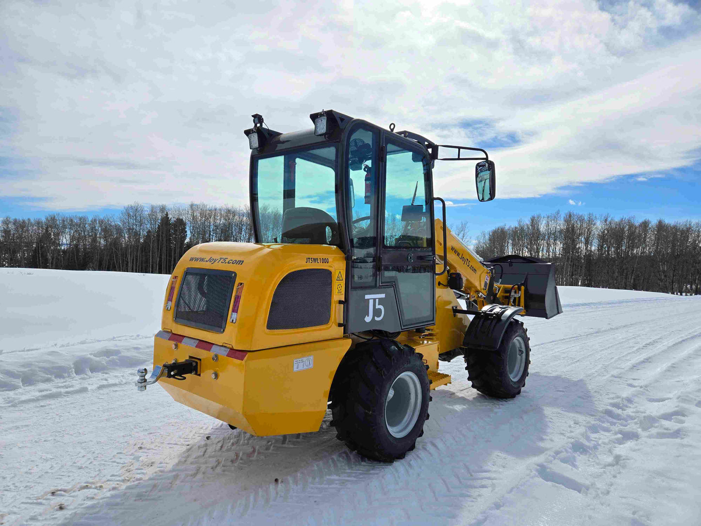 JT5WL1000 compact wheel loader 1 ton working on snowy ground in Canada with bucket attachment for farm and construction use