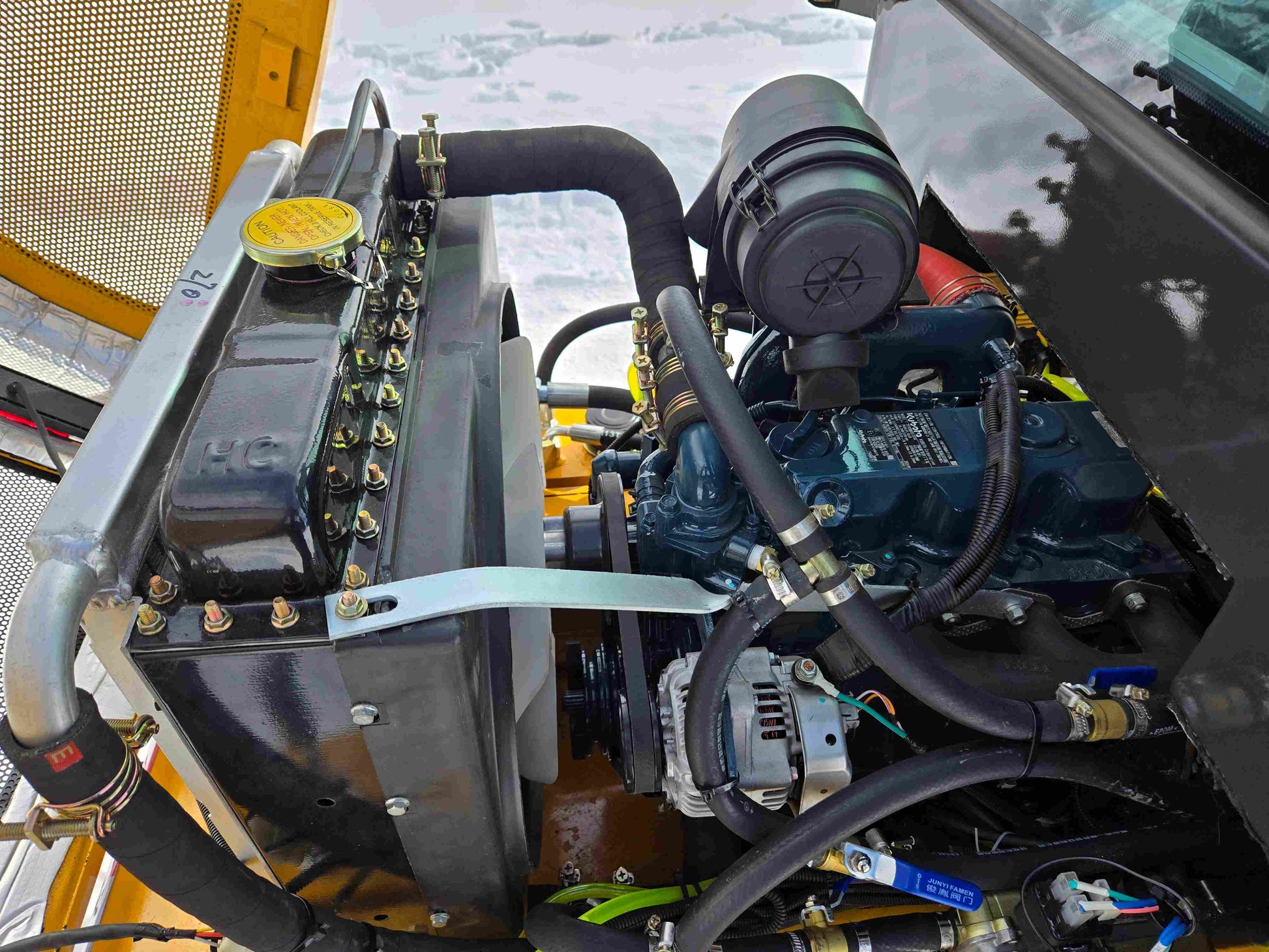 JT5WL1000 compact wheel loader 1 ton 2200 lbs for sale in Canada showing close-up of engine, radiator, and air filter system.