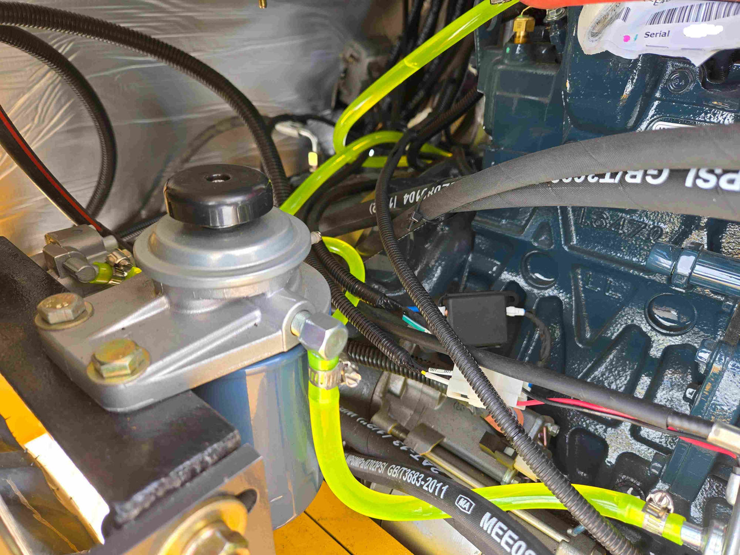 JT5WL1000 compact wheel loader 1 ton 2200 lbs for sale in Canada showing close-up view of engine parts, hoses and fuel system components.