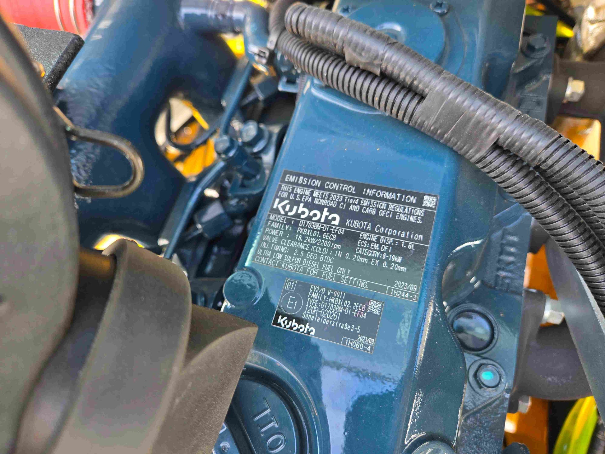 JT5WL1000 compact wheel loader 1 ton 2200 lbs for sale in Canada with Kubota engine label close-up showing emission control information.