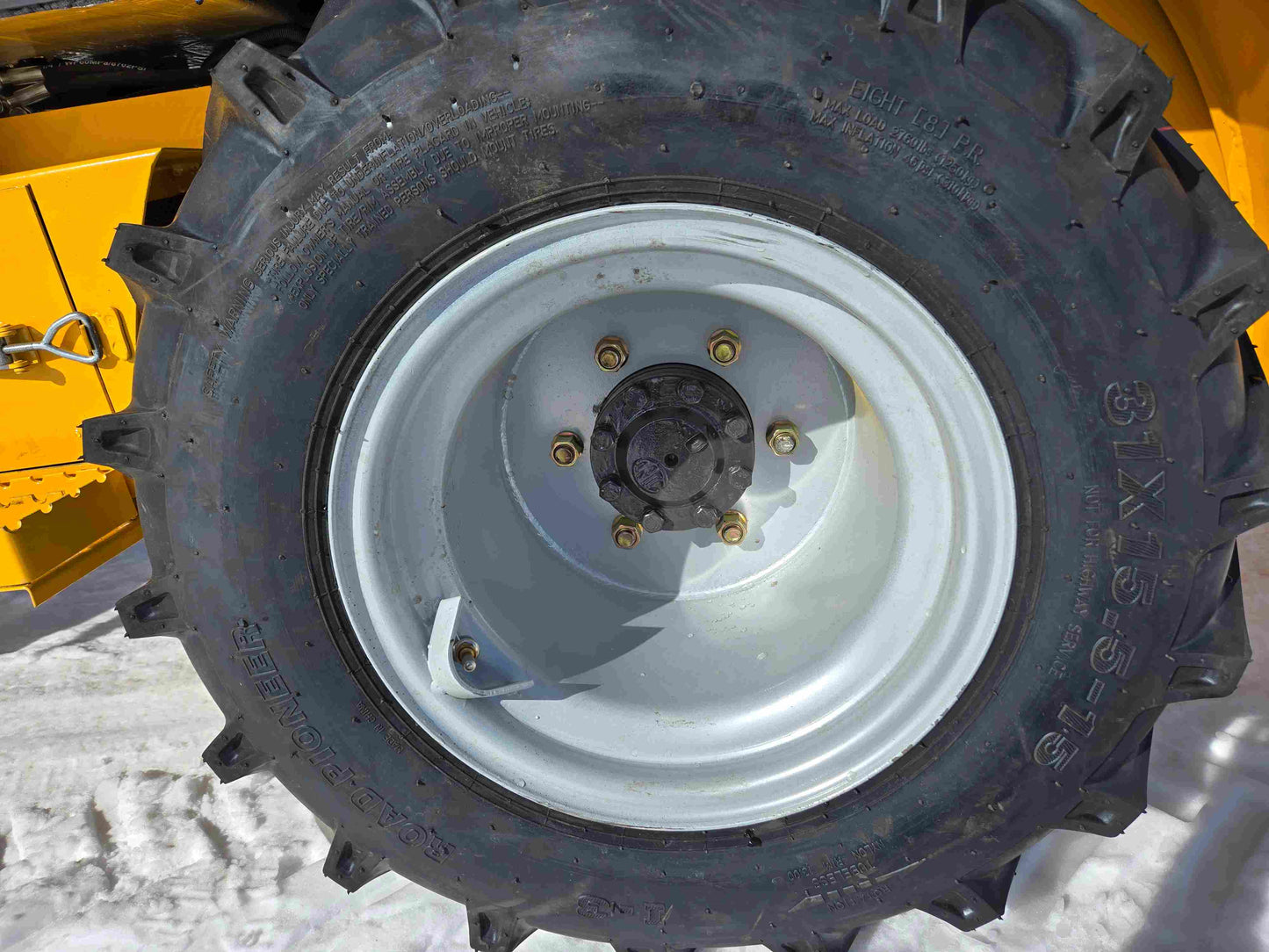 JT5WL1000 compact wheel loader heavy duty tire closeup on snow in Canada showing durable traction for farm construction and landscaping work