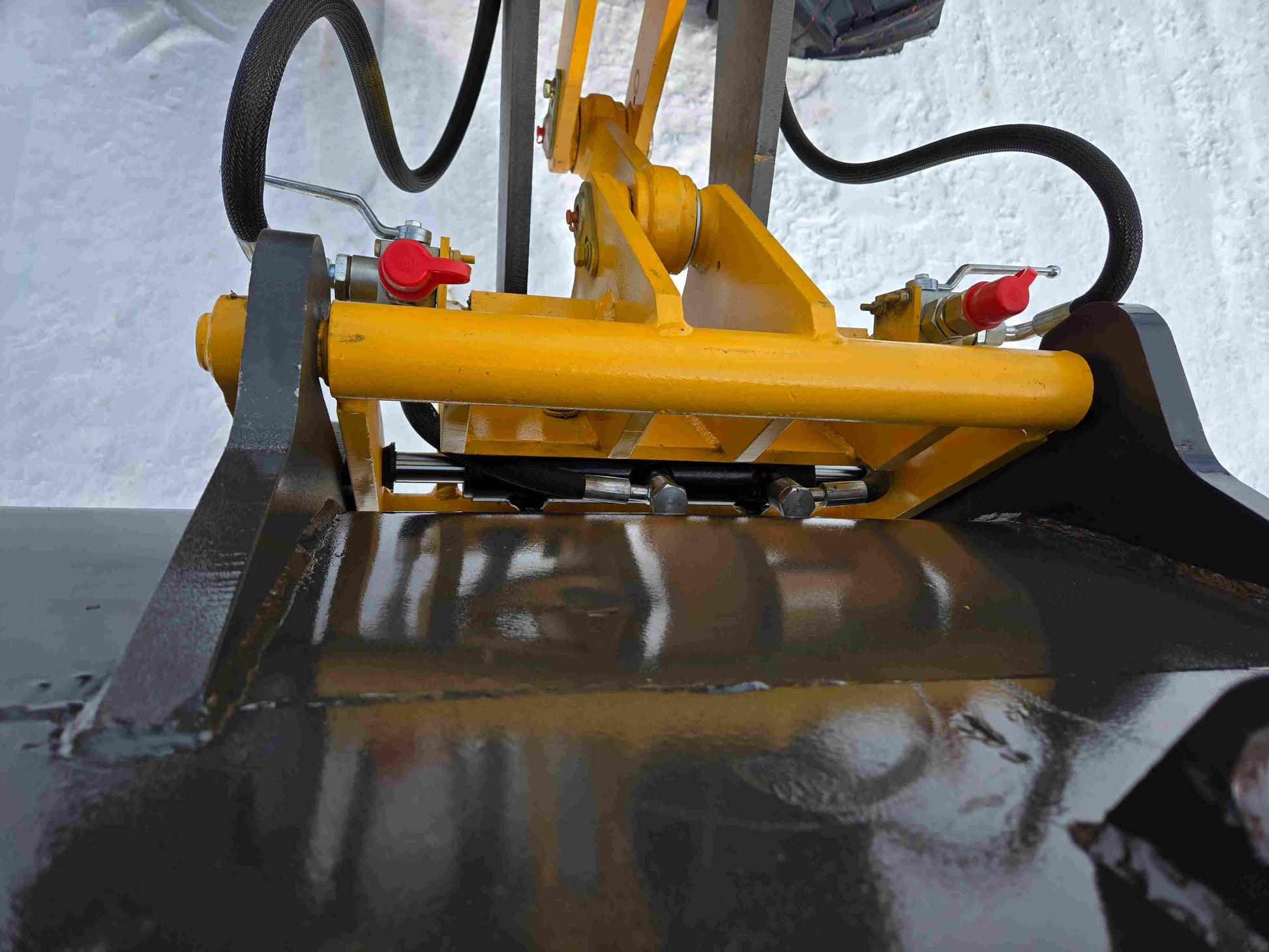 Close-up of JT5WL1000 mini wheel loader bucket hydraulic cylinder and hose system for heavy-duty operation.