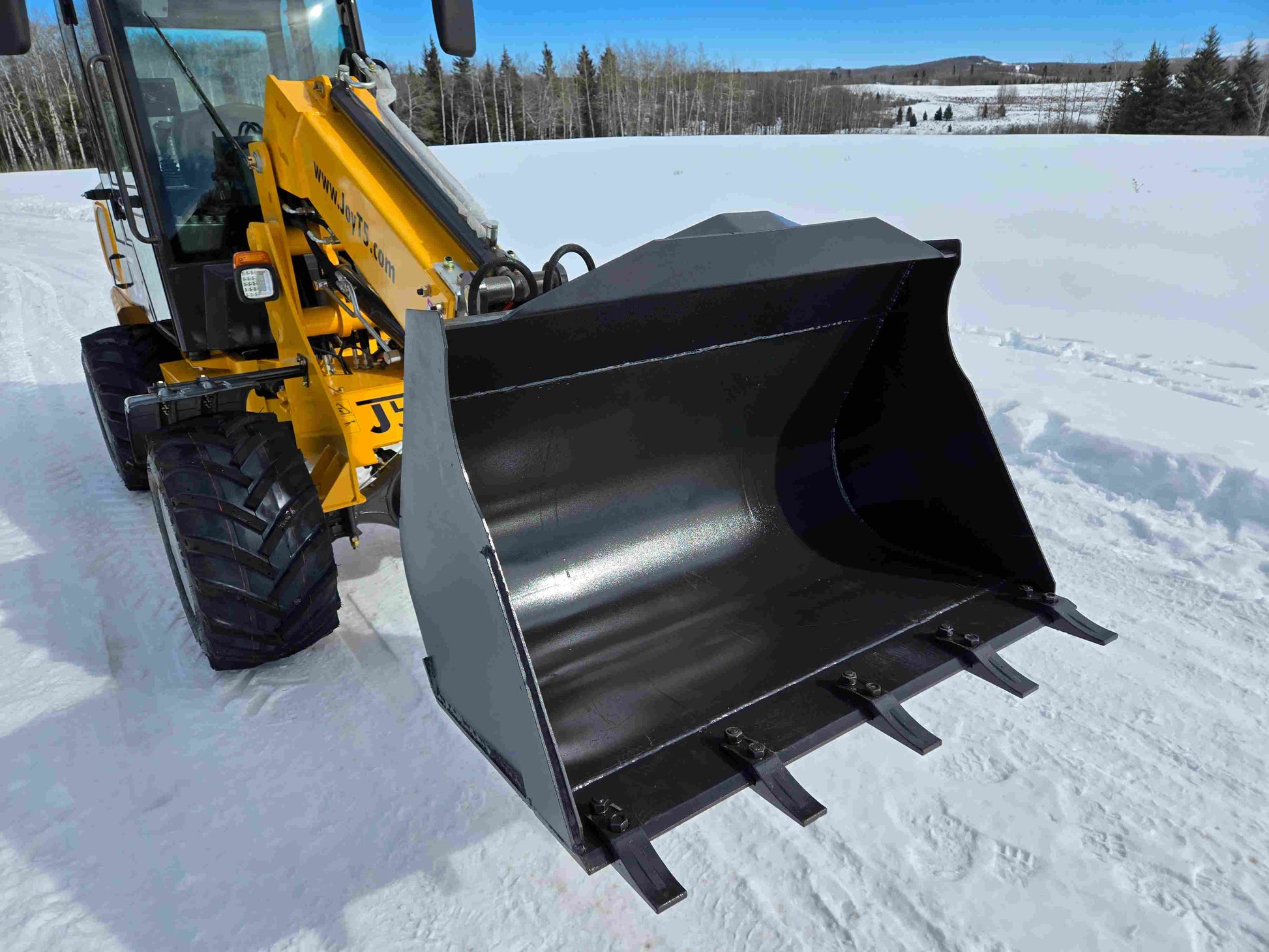 Close-up view of JT5WL1000 mini wheel loader heavy-duty bucket with reinforced teeth for efficient snow and material handling.