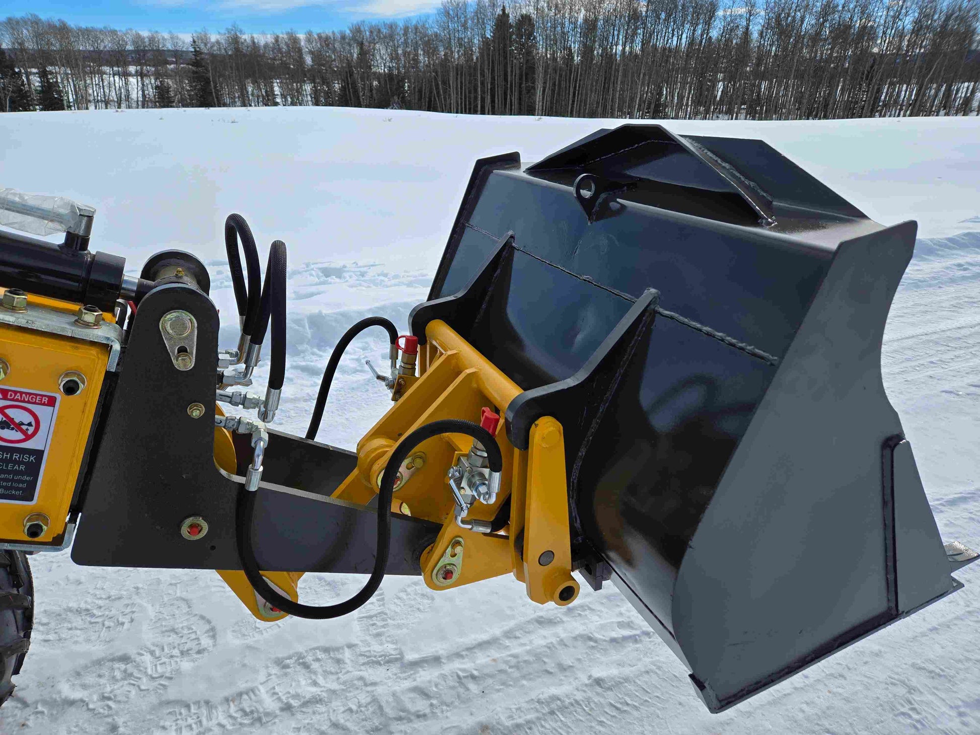 JT5WL1000 compact wheel loader bucket attachment on snow covered job site in Canada for farm landscaping and construction use