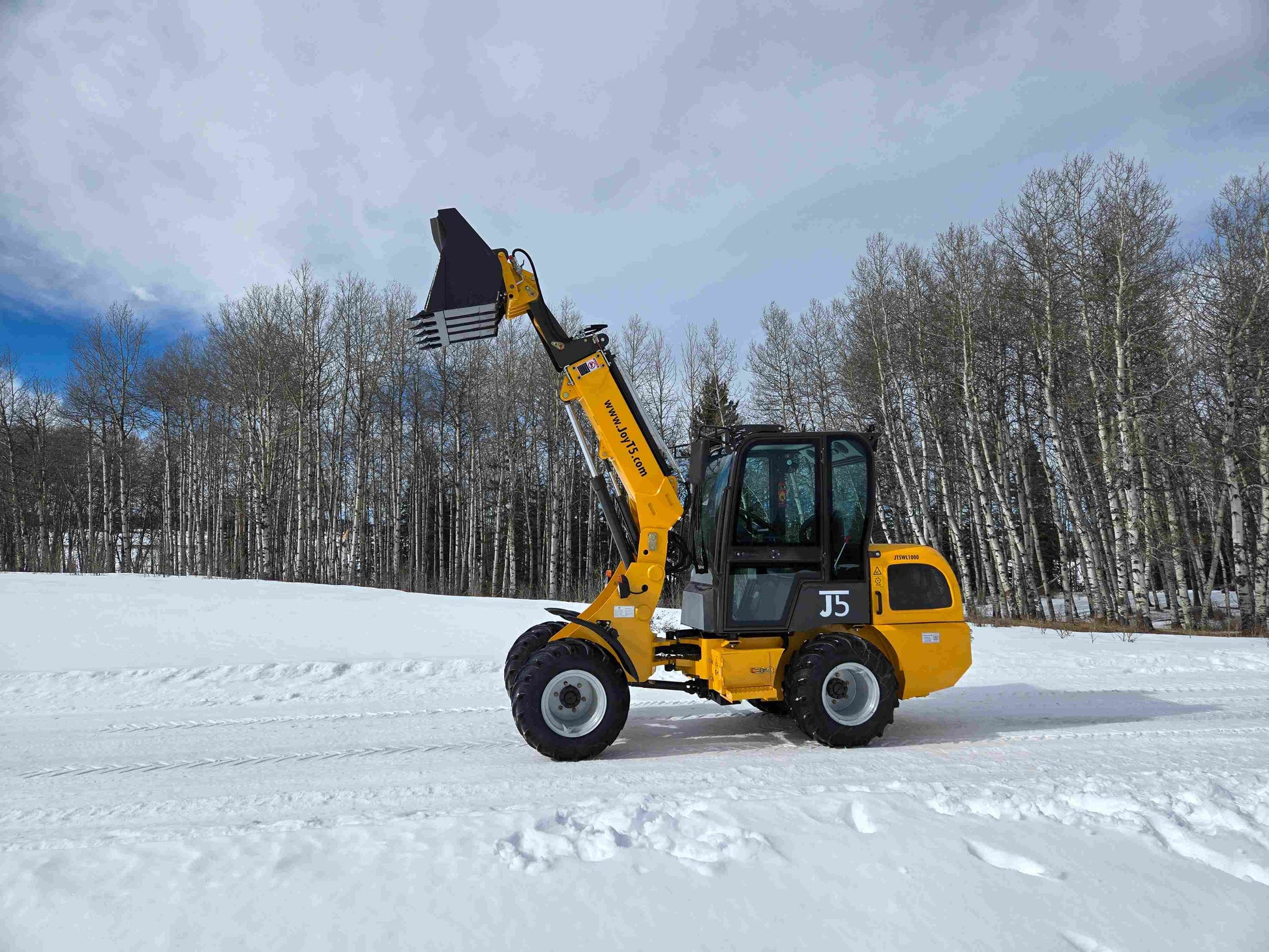 One ton compact wheel loader lifting bucket attachment on snow for farm and construction use in Canada