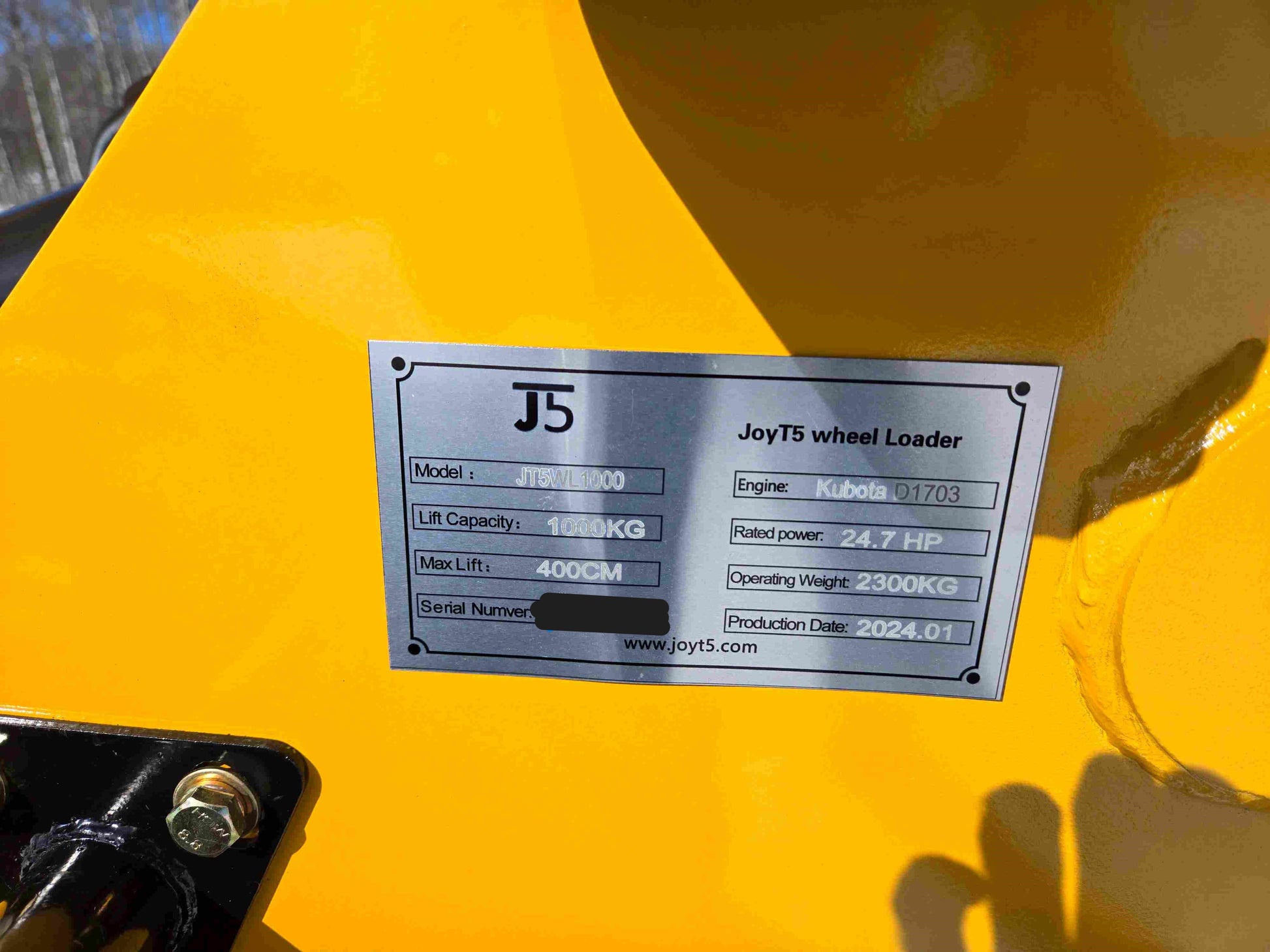 JT5WL1000 wheel loader specification plate showing model, lift capacity, max lift, engine, rated power, operating weight, and production date.