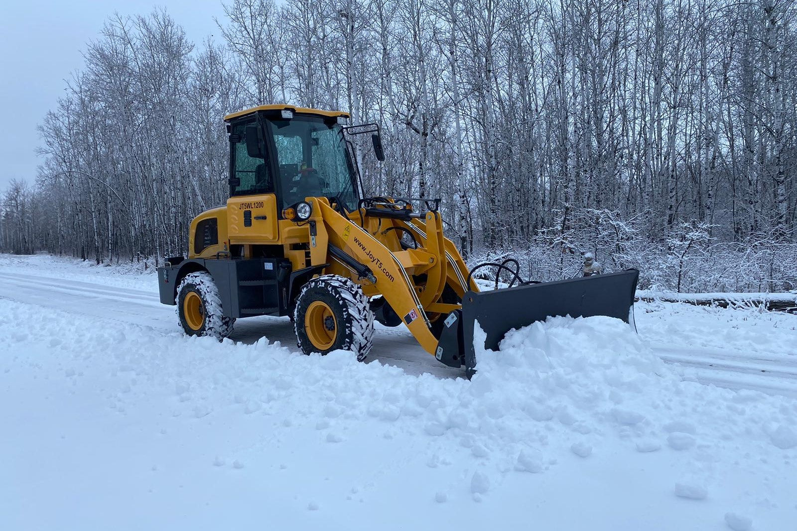 JT5WL1200 compact wheel loader 1.2 ton 2650 lbs for sale Canada, powerful mini wheel loader pushing snow on winter road, ideal for farms, landscaping and construction.
