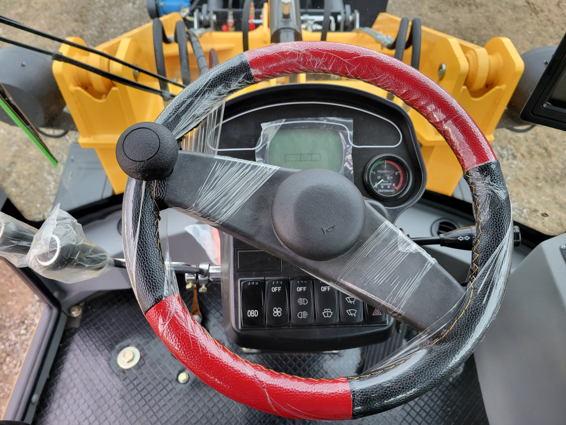 JT5WL1200 compact wheel loader 1.2 ton 2650 lbs steering wheel and dashboard view. High-performance small wheel loader for farms, landscaping, and construction in Canada.