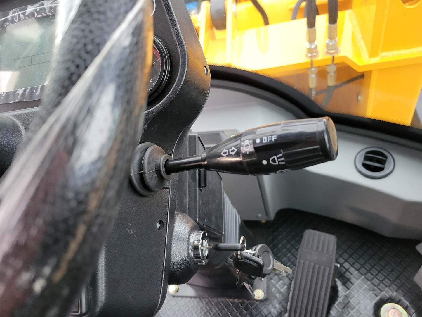 JT5WL1200 compact wheel loader 1.2 ton 2650 lbs ignition key and control lever inside cabin. Reliable small wheel loader for farms, landscaping, and construction in Canada.