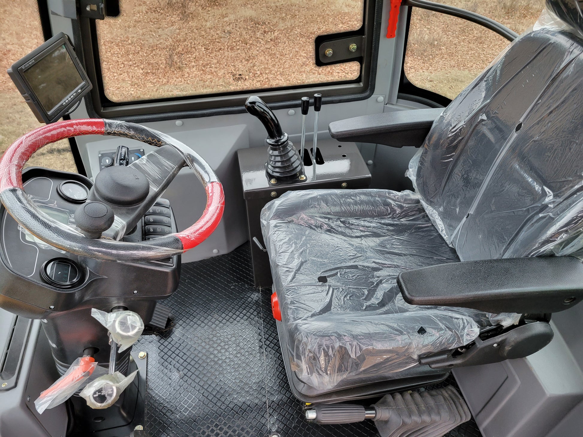 JT5WL1200 compact wheel loader cabin interior with operator seat, steering wheel and control levers for sale in Canada