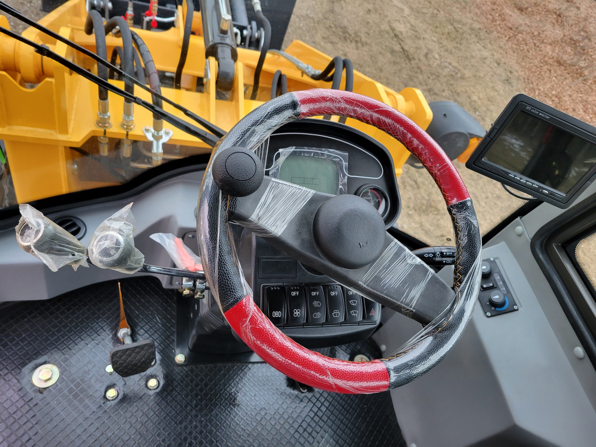 JT5WL1200 compact wheel loader driver view showing steering wheel pedal and control monitor for construction and farm applications in Canada