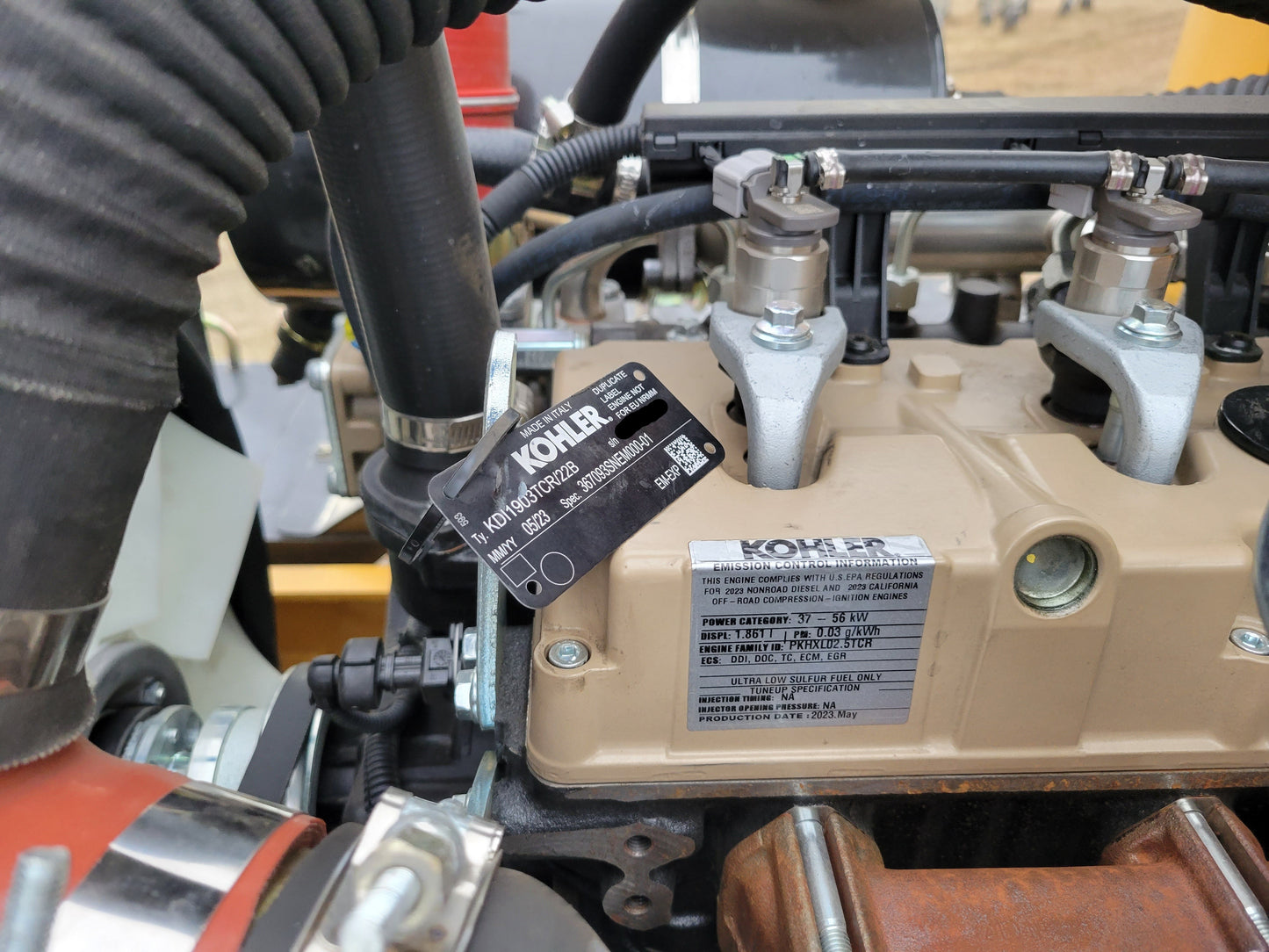 JT5WL1200 compact wheel loader engine closeup showing fuel injection system and specification label for powerful construction performance in Canada