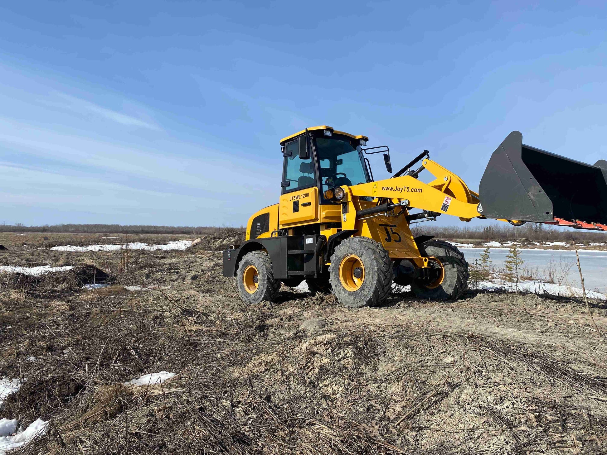 JT5WL1200 compact wheel loader operating front bucket for soil lifting and construction work in Canada