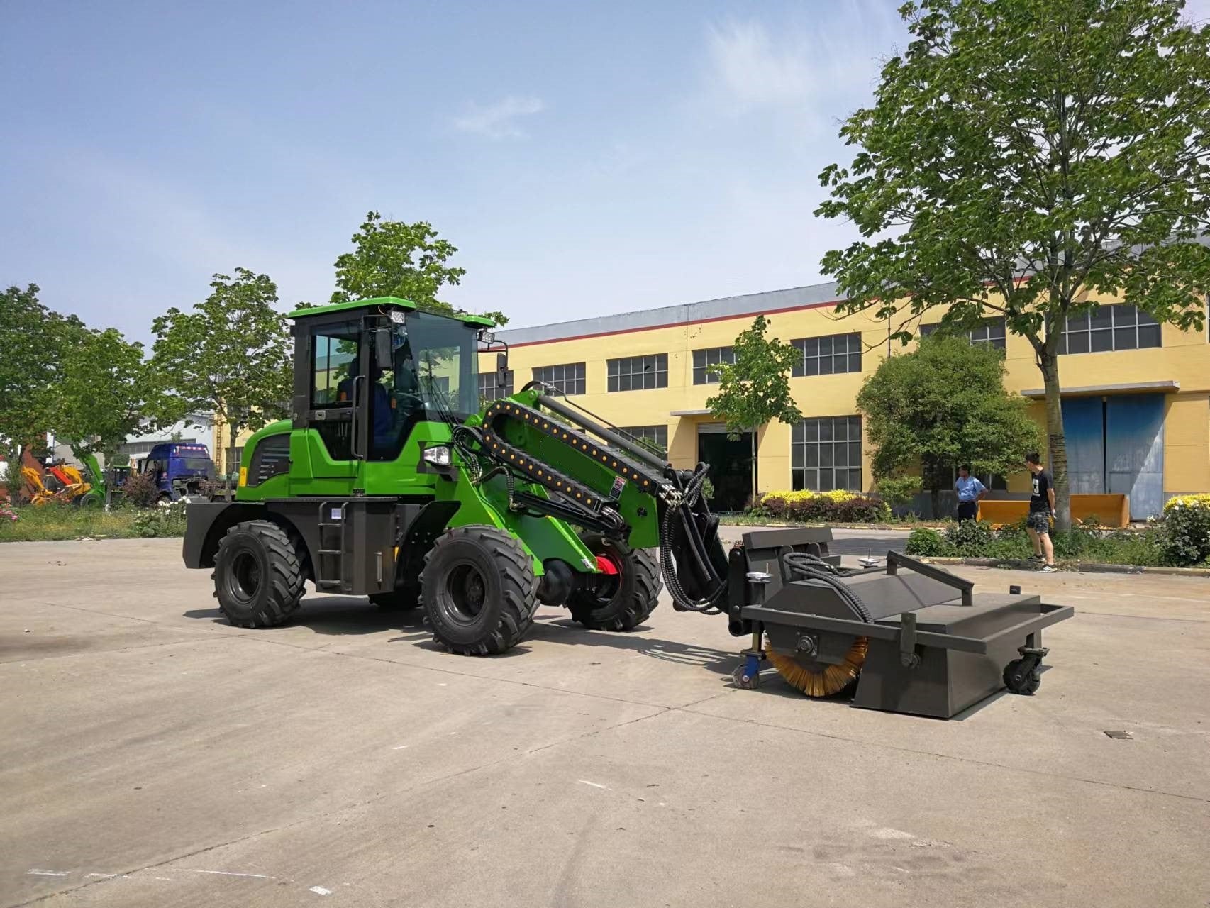 JT5WL1200 compact wheel loader with sweeper attachment cleaning road and construction area in Canada