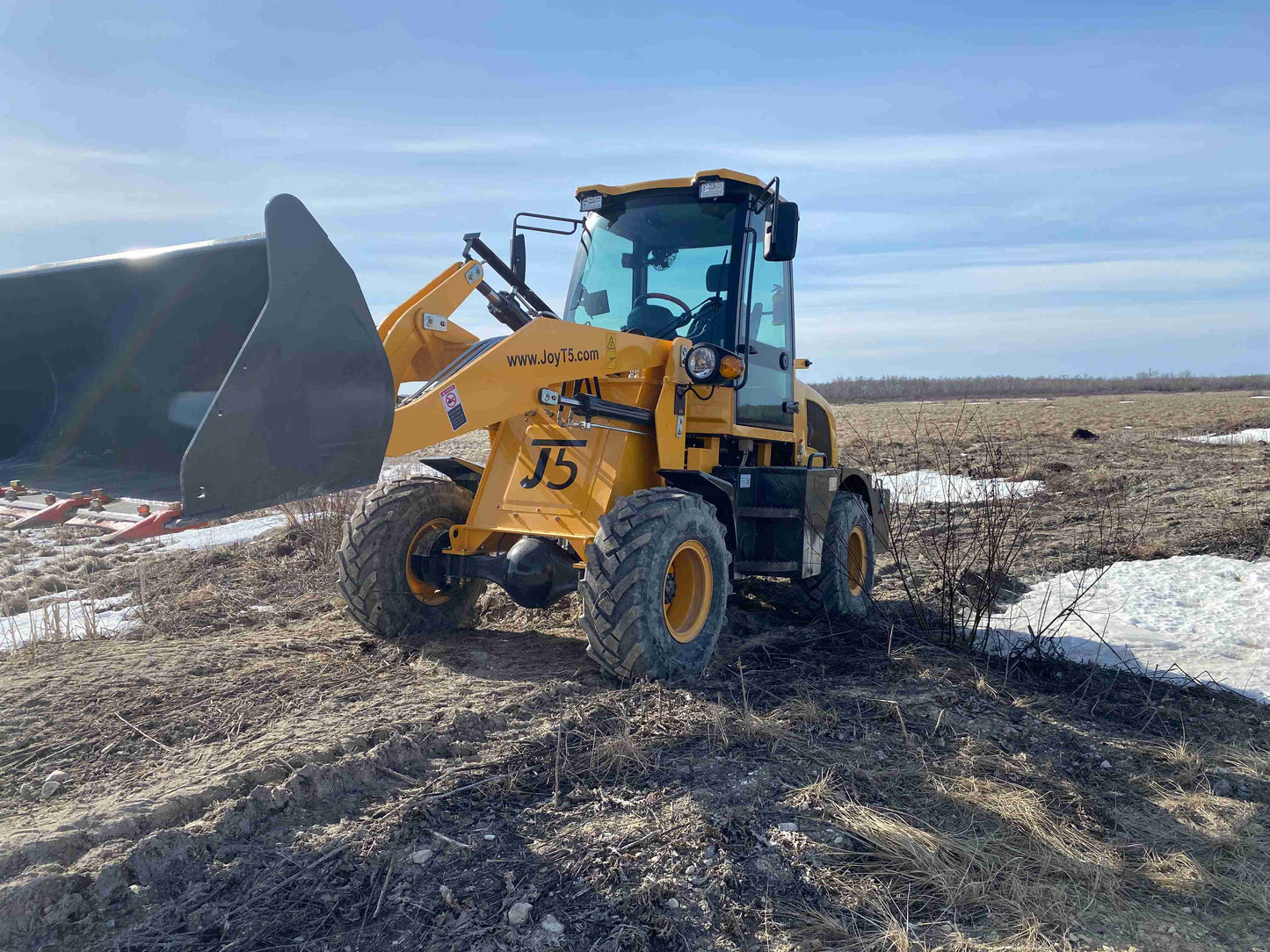 JT5WL1200 wheel loader lifting bucket in field - compact construction loader for earthmoving and material handling