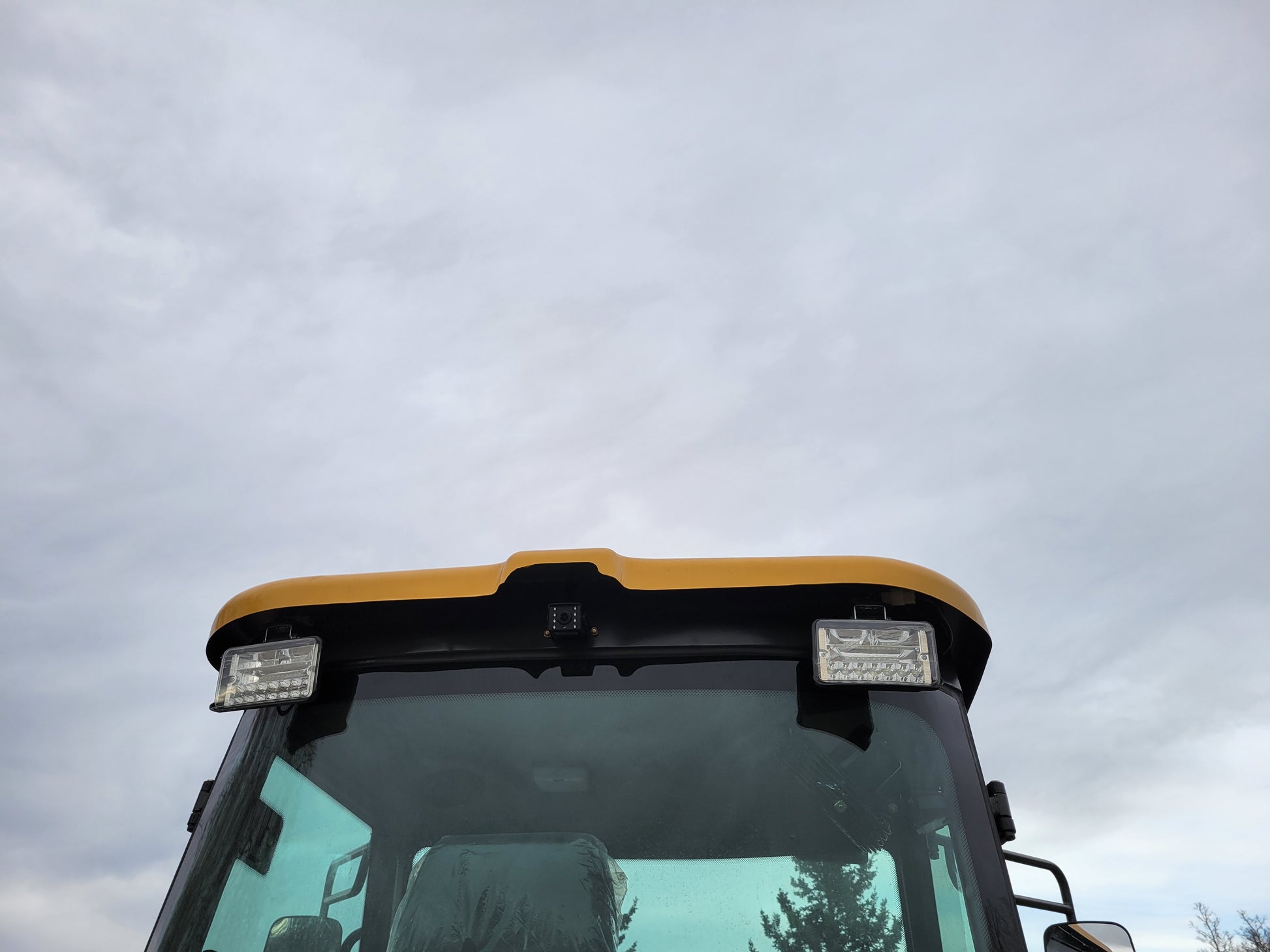 Close-up view of JT5WL1200 wheel loader cabin roof with LED work lights and windshield.