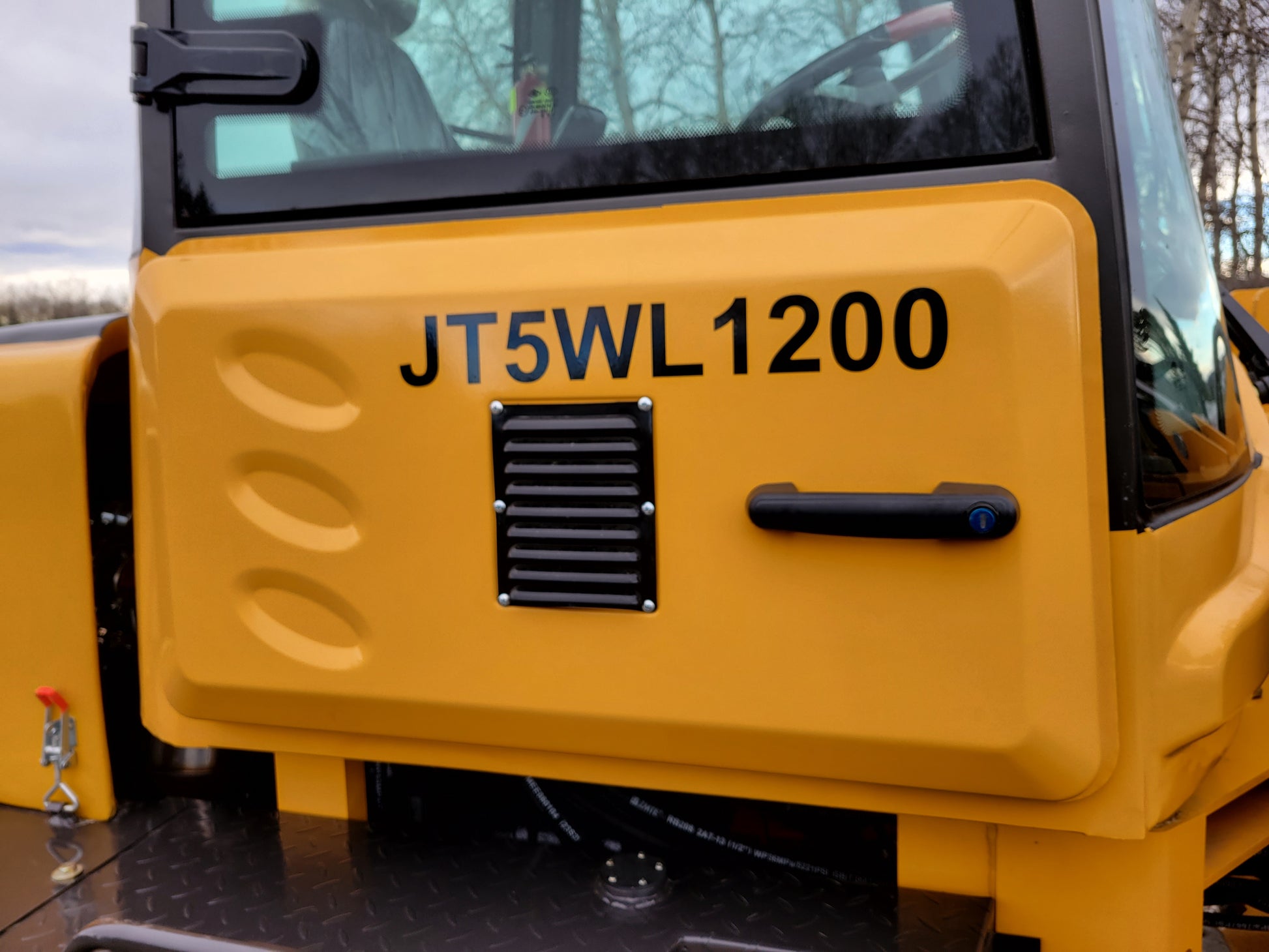 JT5WL1200 wheel loader cabin side view with model marking on yellow body.