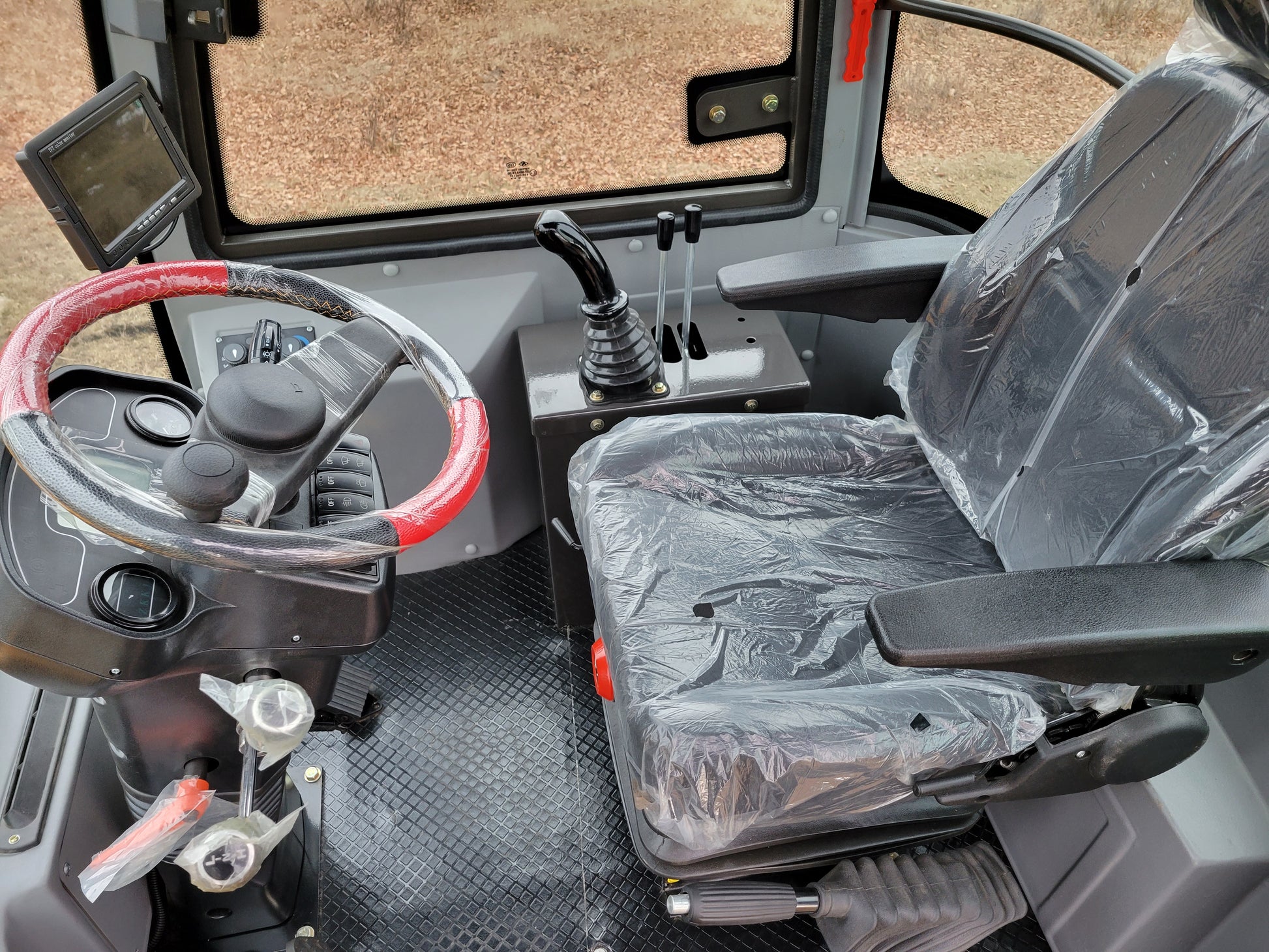 JT5WL1200 wheel loader cabin view with driver seat, joystick controls and steering wheel in Canada