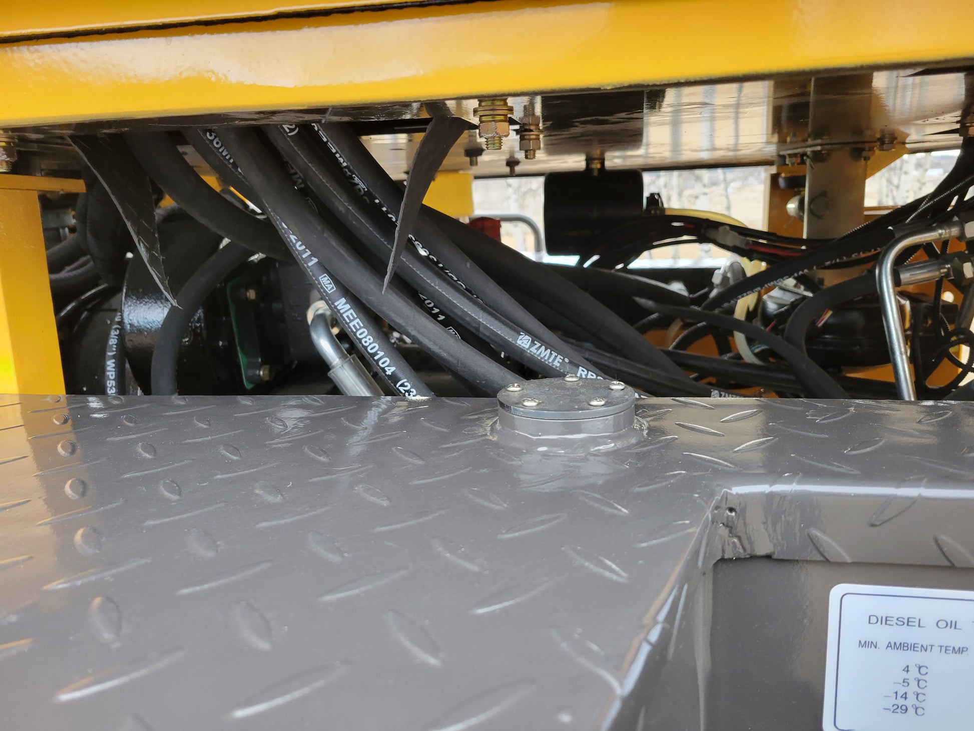 JT5WL1200 wheel loader hydraulic hoses and fluid lines with visible diesel oil label and metal platform.
