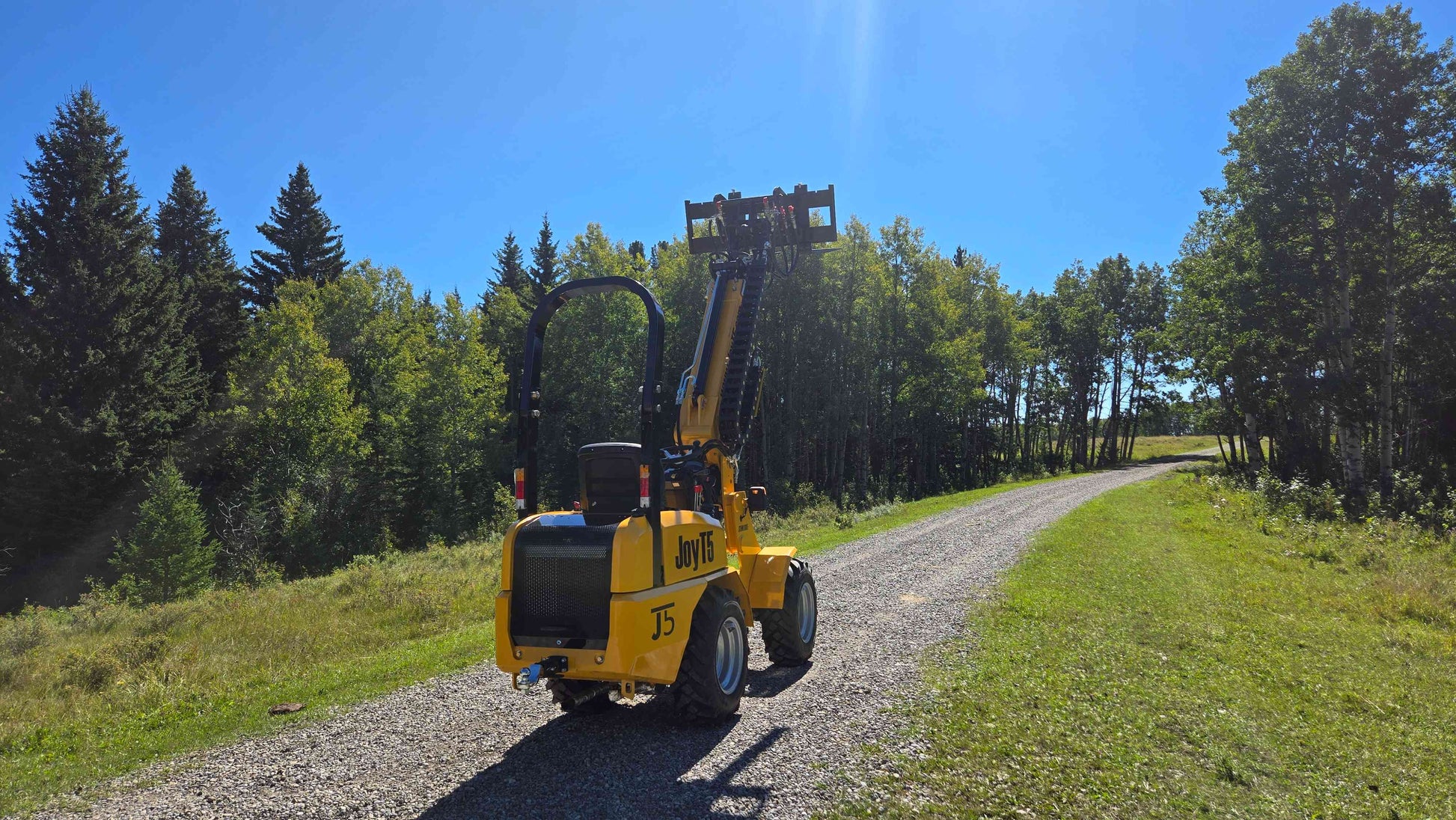 JT5WL800 compact mini wheel loader 800kg 1750 lbs rear view with raised boom and pallet fork attachment
