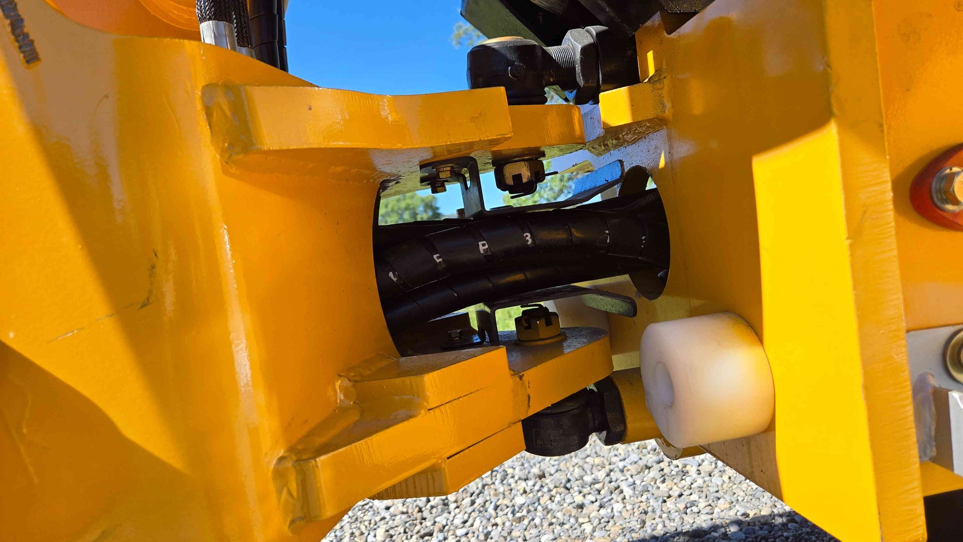 Center articulation joint and hose channel of the JT5WL800 compact wheel loader showing the pivot housing and protected hydraulic lines for smooth farm landscaping and construction use across Canada