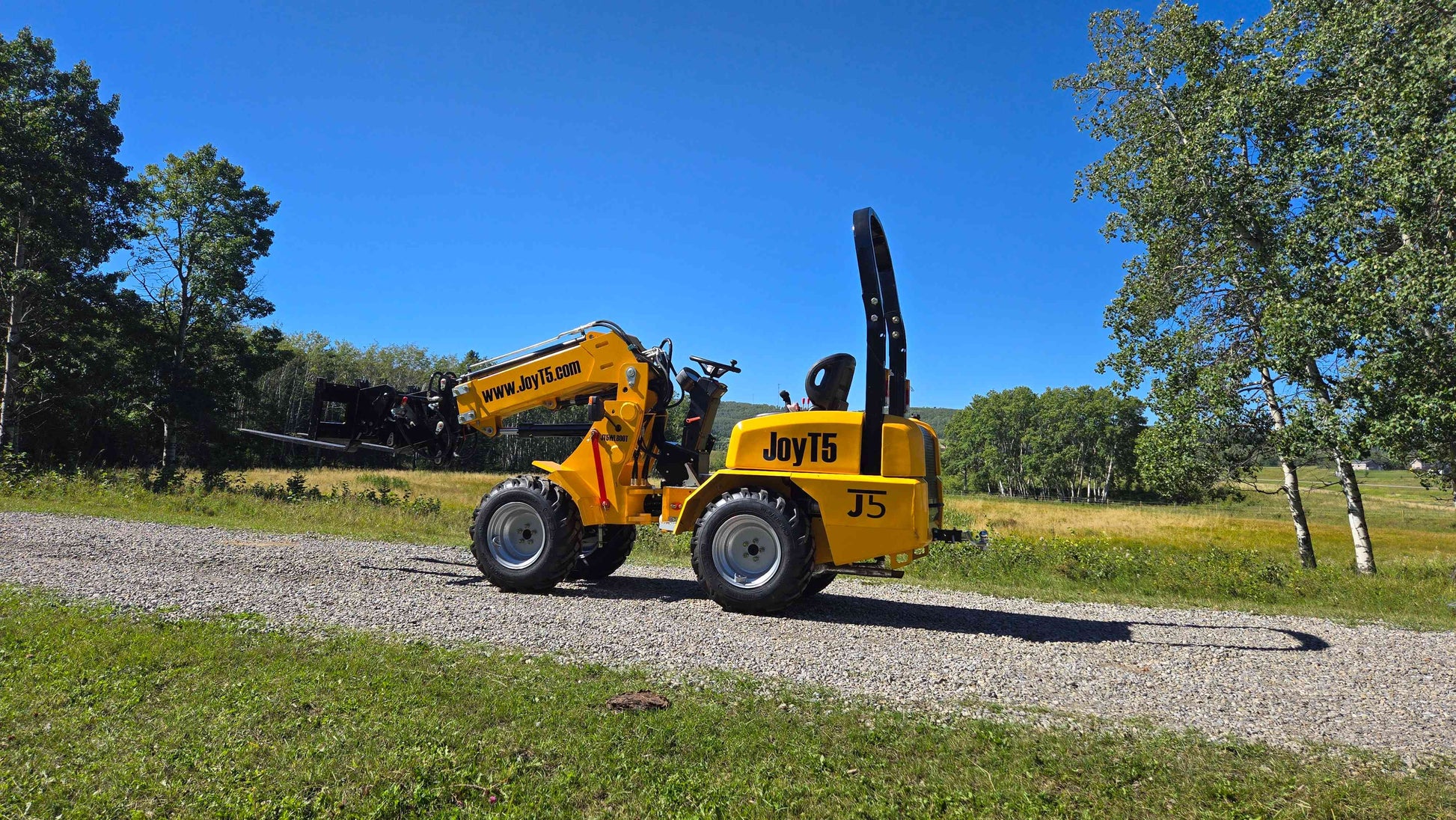 JT5WL800 compact wheel loader extending forklift attachment forward for construction farm and landscaping work in Canada