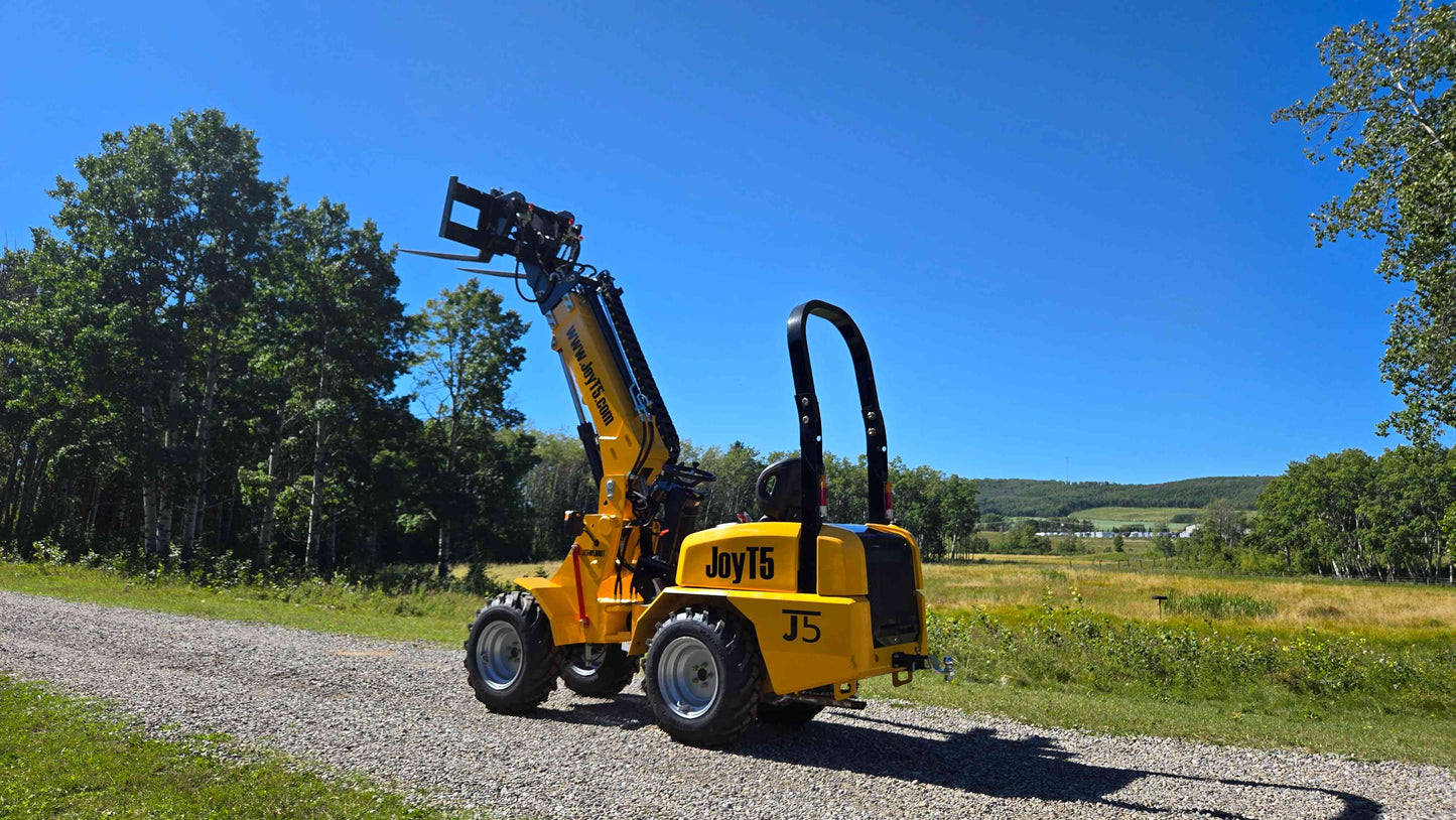 JT5WL800 compact wheel loader with extended forklift attachment lifting load for construction landscaping and farm work in Canada