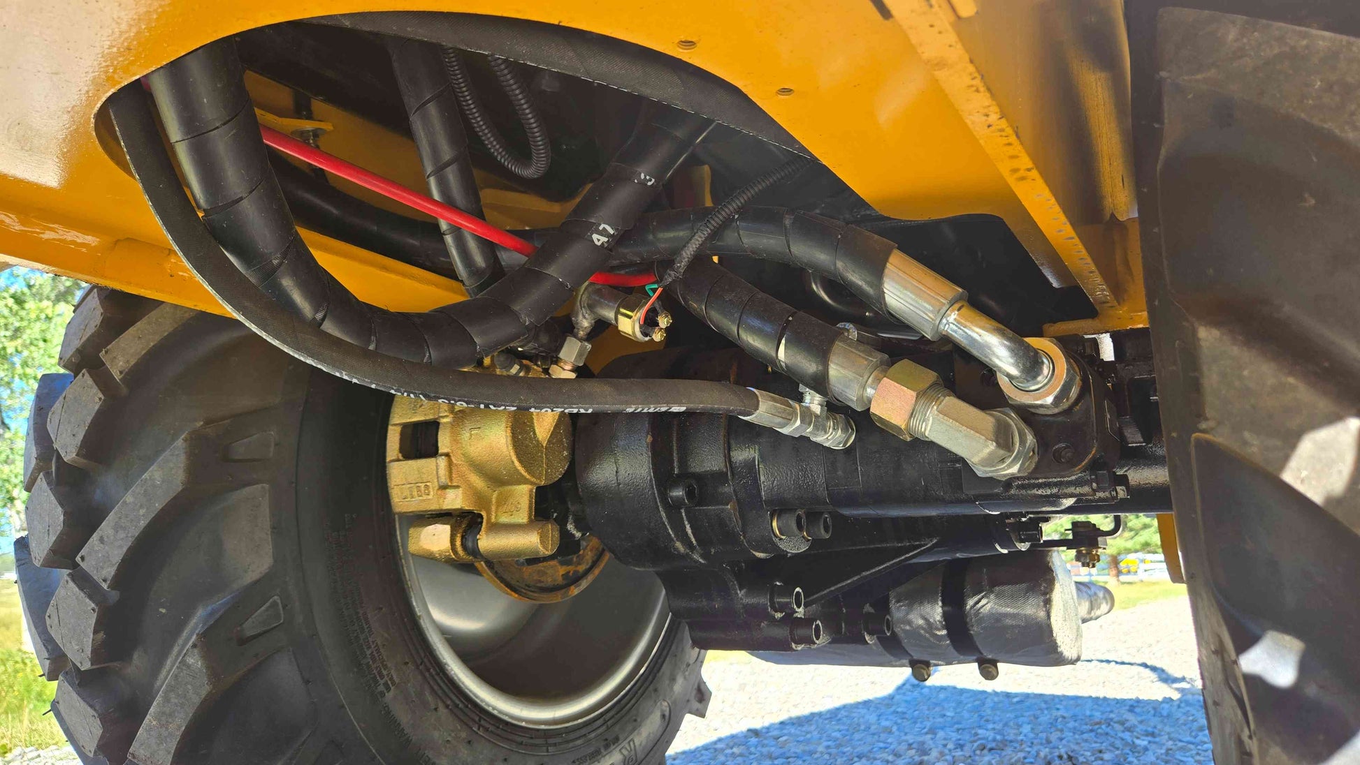 Hydraulic drive assembly brake caliper and hose routing under the JT5WL800 compact wheel loader shown in a clear close view for dependable farm landscaping and construction work across Canada