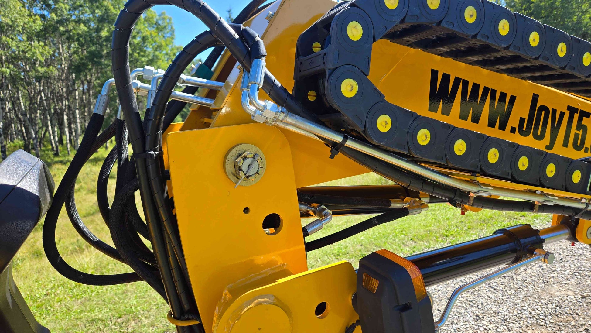 Hydraulic lines protective hose routing and boom frame section of the JT5WL800 compact wheel loader shown in a close view for reliable farm landscaping and construction work across Canada