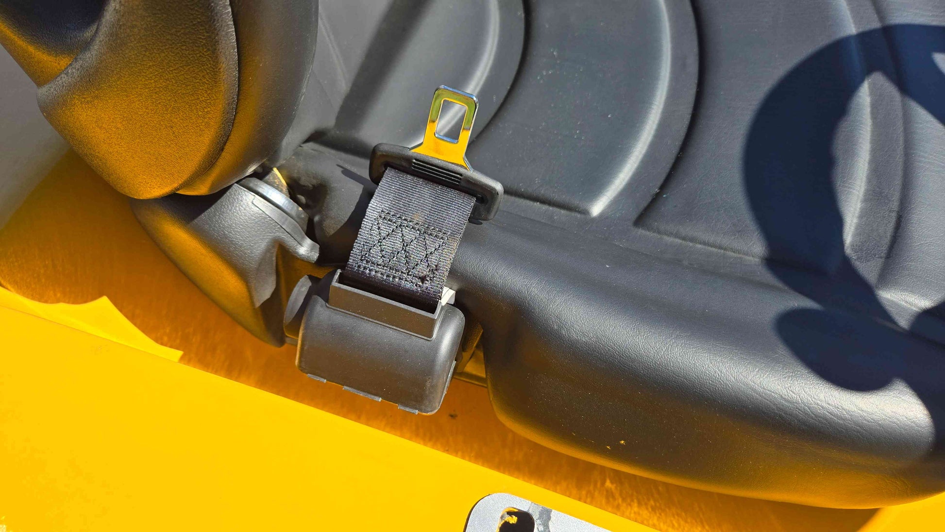 Seat belt latch on the operator seat of the JT5WL800 compact wheel loader shown in a close view for safe operation during farm landscaping and construction work across Canada