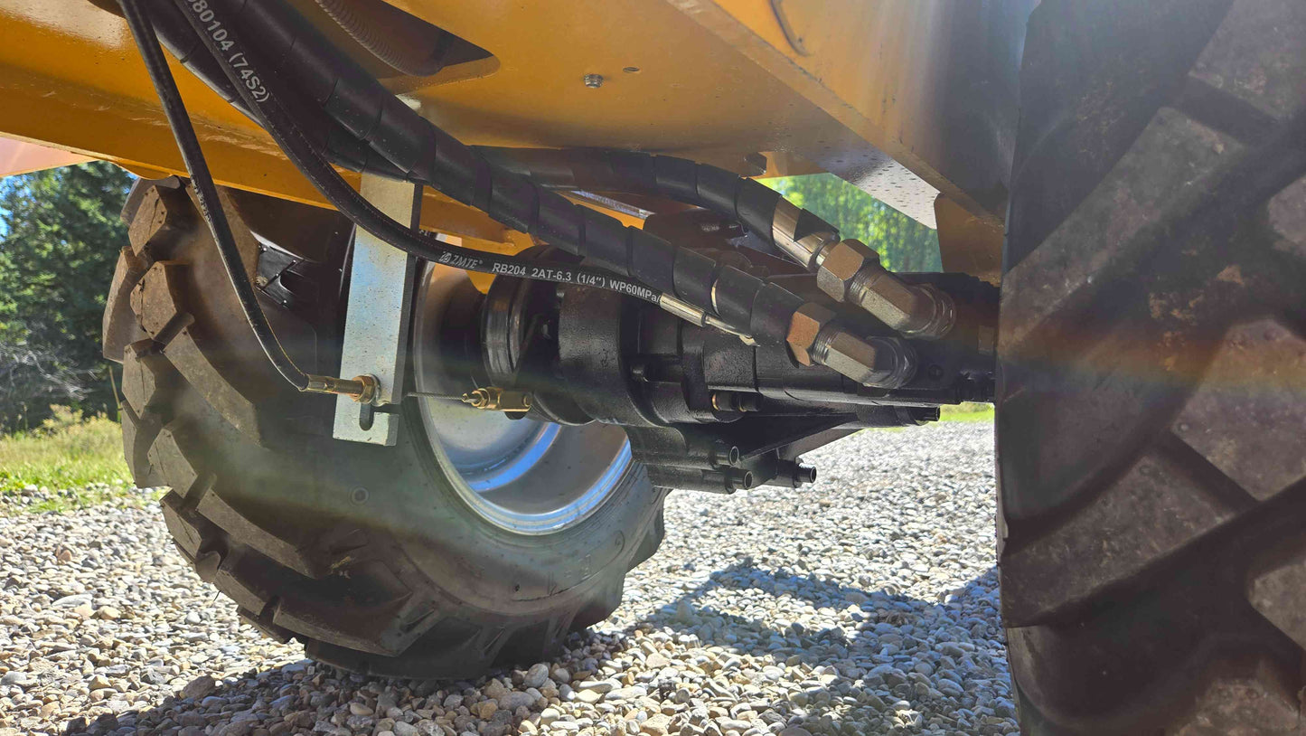 Steering cylinder axle connection and hydraulic hose layout underneath the JT5WL800 compact wheel loader shown in a close ground level view for reliable farm landscaping and construction work across Canada