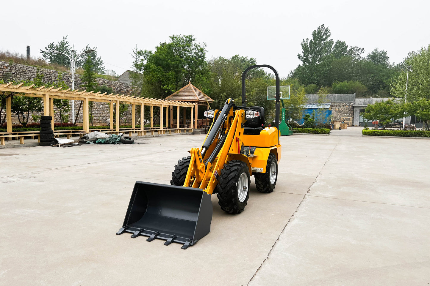 Front view of JT5WL800 Mini Loader in yellow – compact wheel loader with heavy duty bucket for farming, landscaping and construction work
