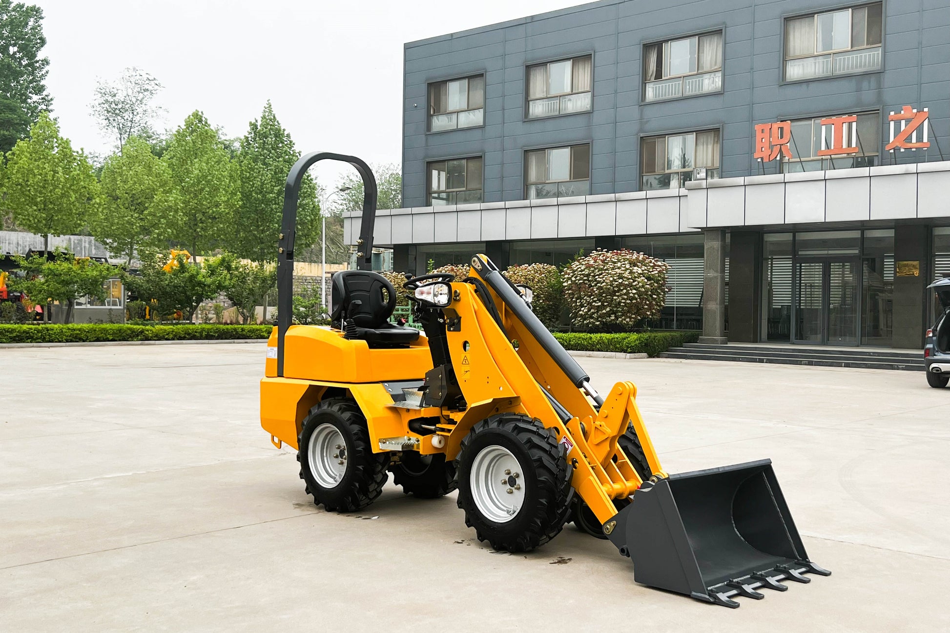 Side angle view of JT5WL800 Mini Loader in yellow with heavy duty bucket, ideal for agriculture, landscaping and small construction projects
