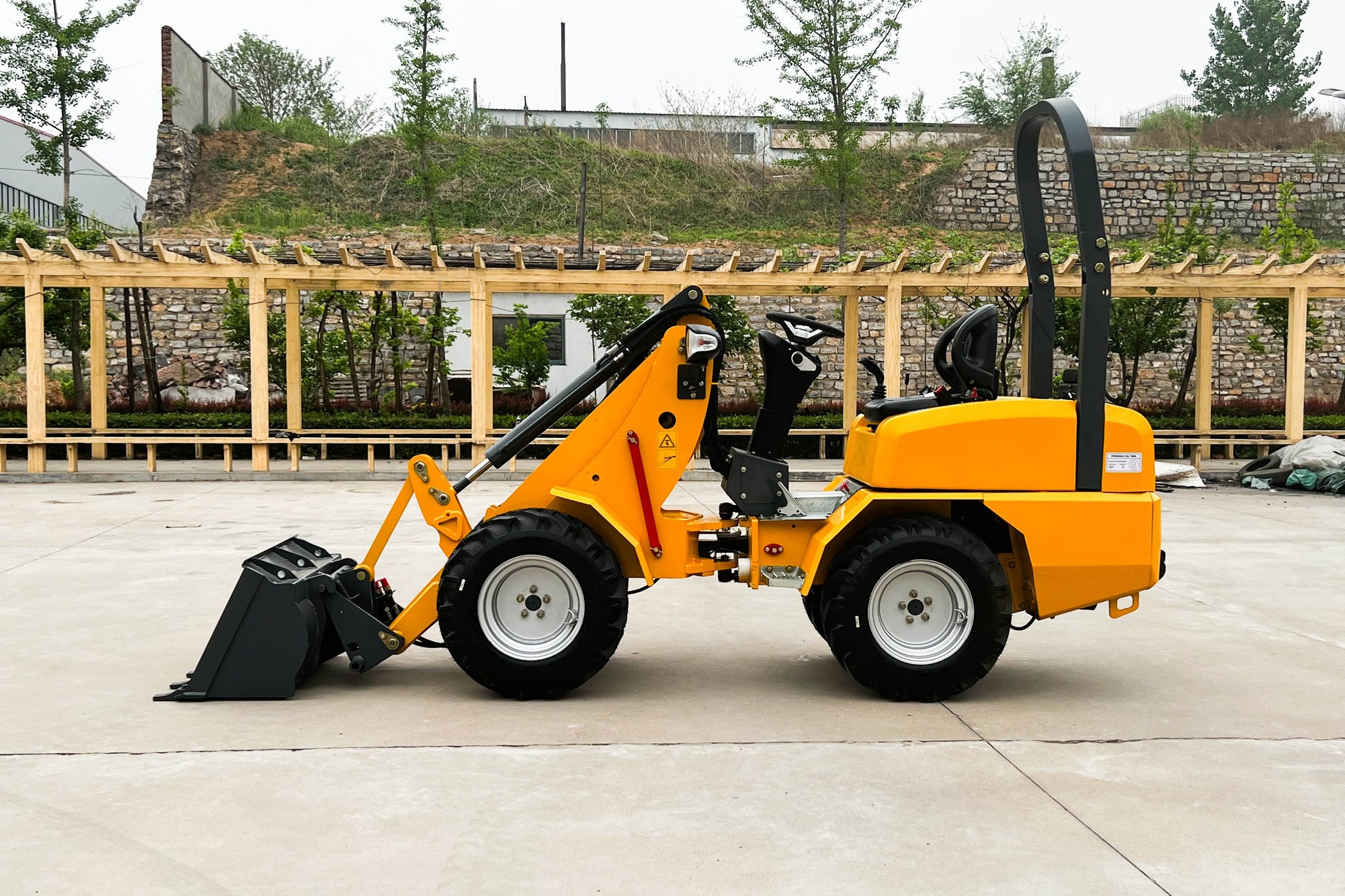Side view of JT5WL800 Mini Loader in yellow – compact wheel loader with front bucket for agriculture, landscaping and construction work