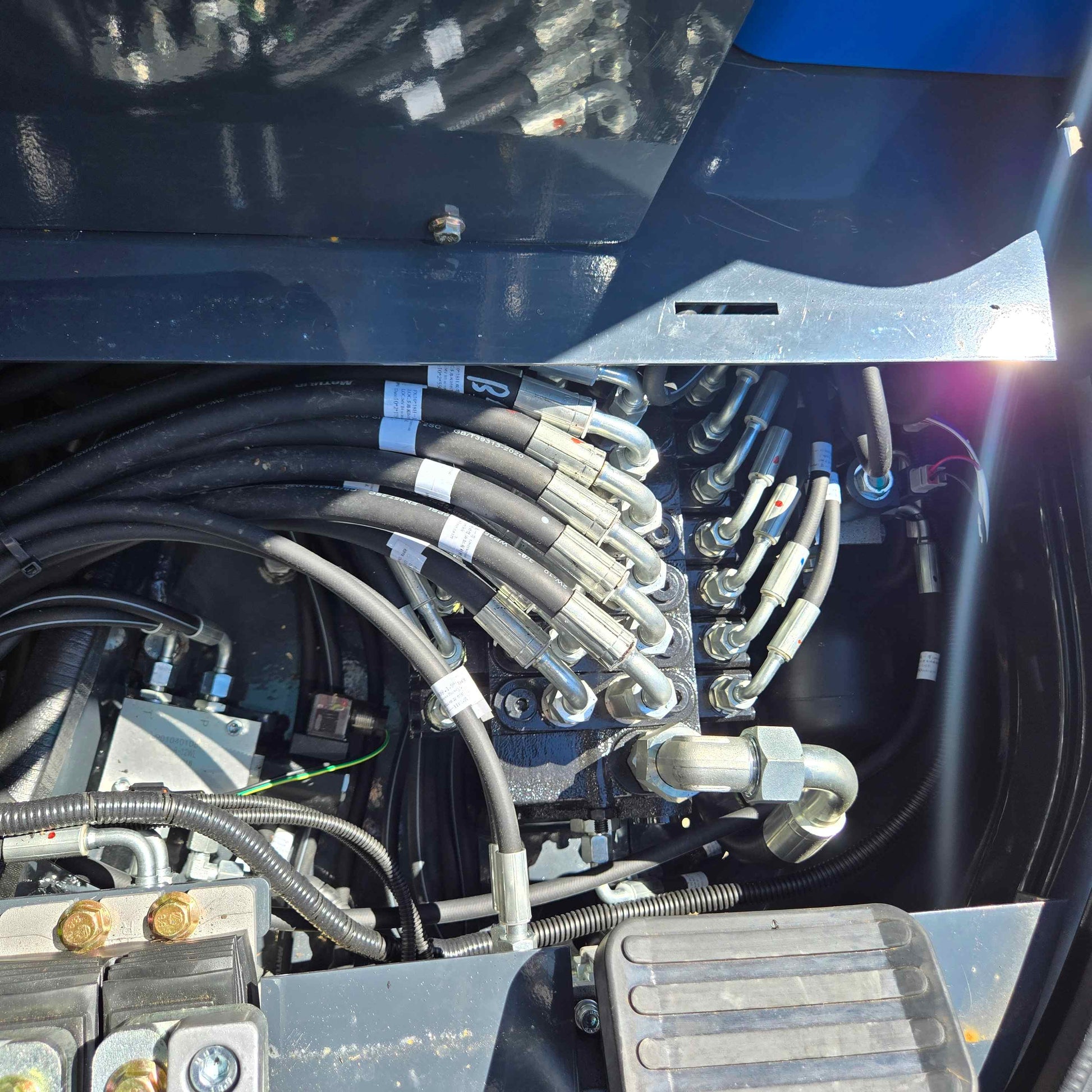 Close up view of the hydraulic hose manifold and valve connections inside a mini excavator used in Canada for JoyT5 customers

